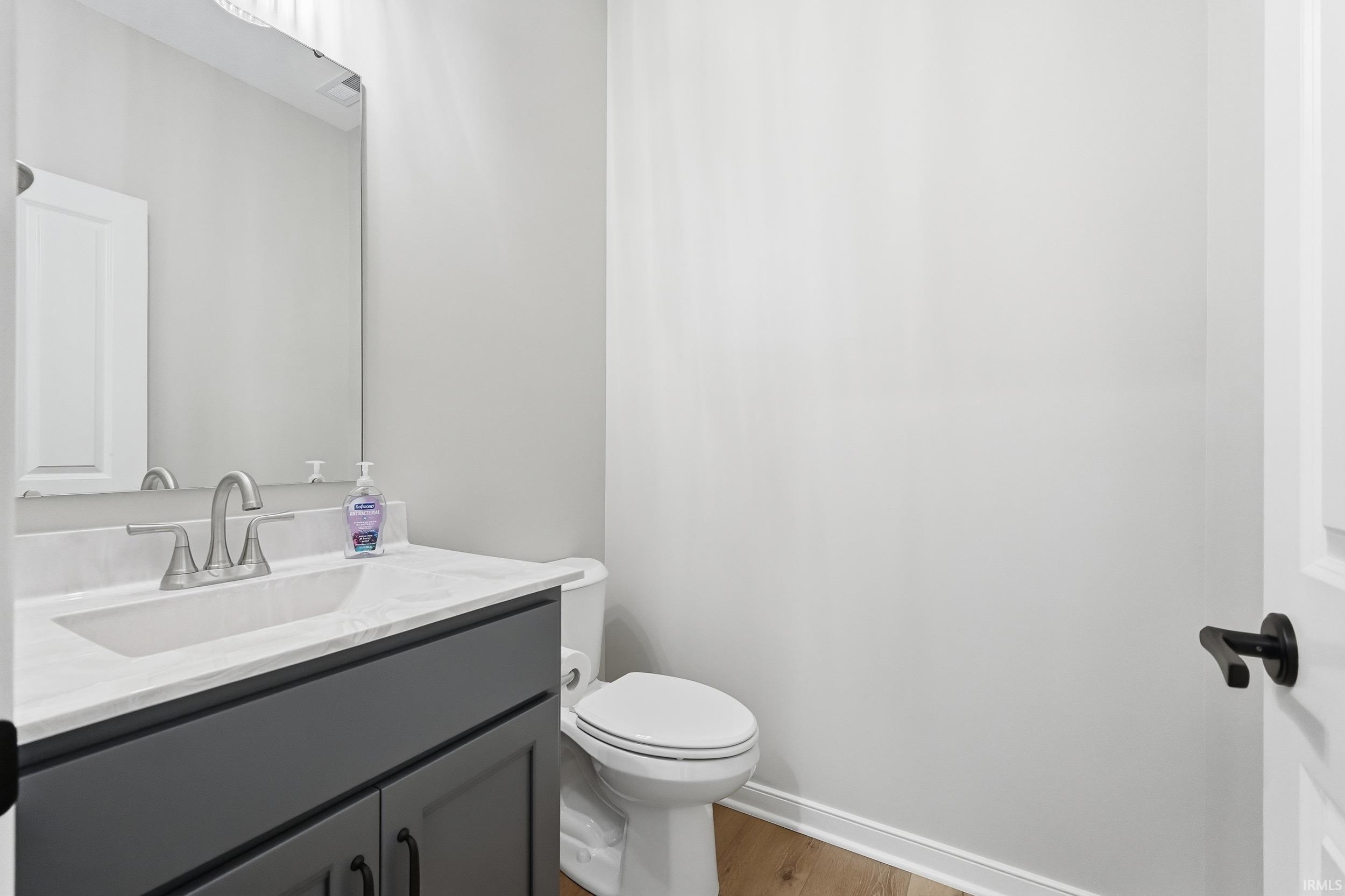 Half bathroom featuring vanity and light wood-type flooring