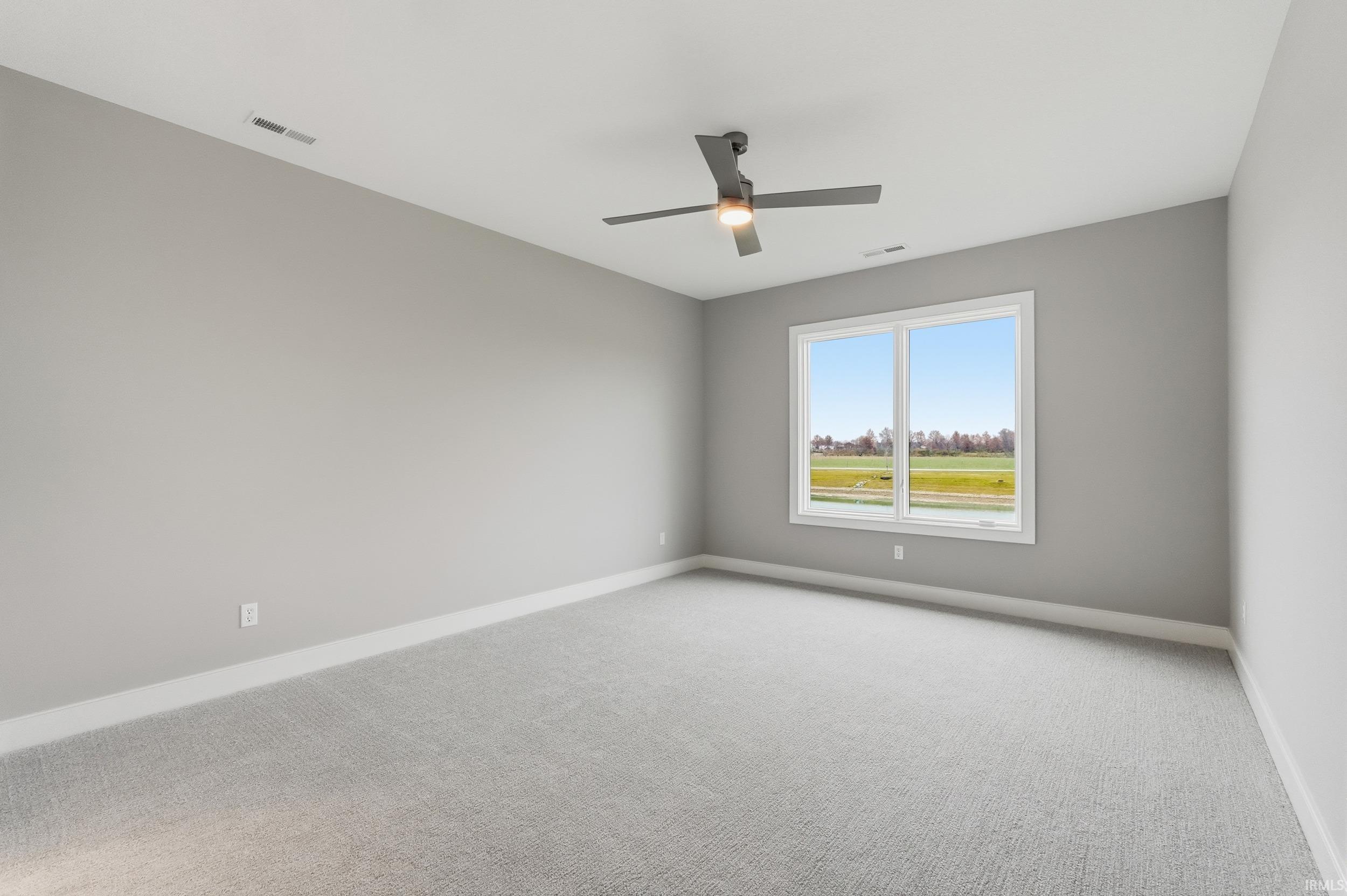 Empty room featuring carpet floors and ceiling fan