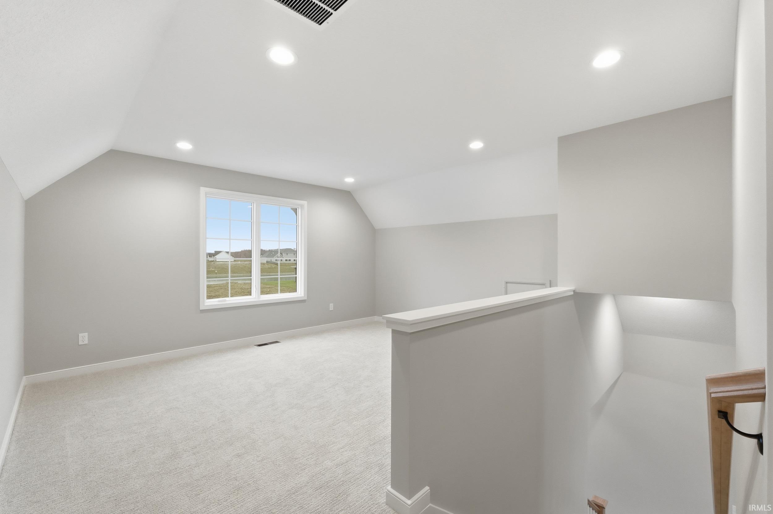 Additional living space featuring vaulted ceiling, light carpet, and recessed lighting