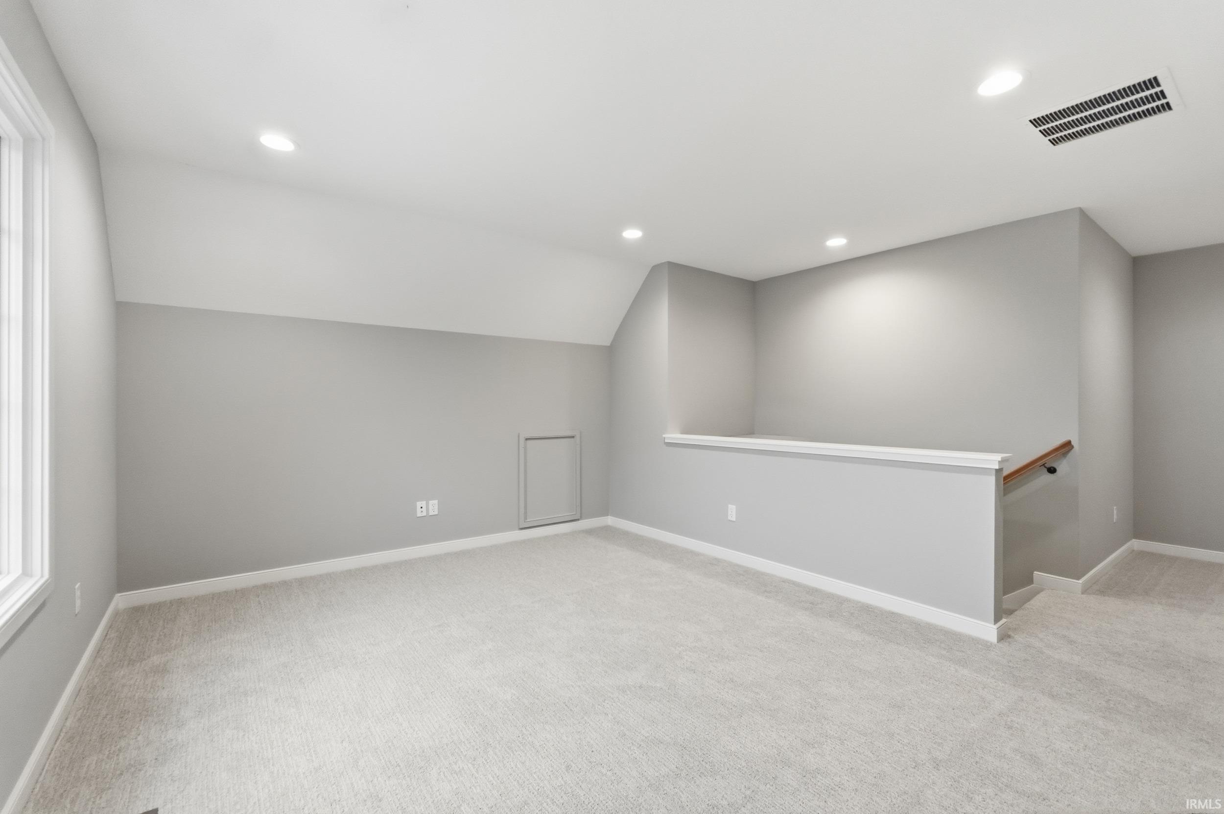 Bonus room with recessed lighting, light colored carpet, and vaulted ceiling