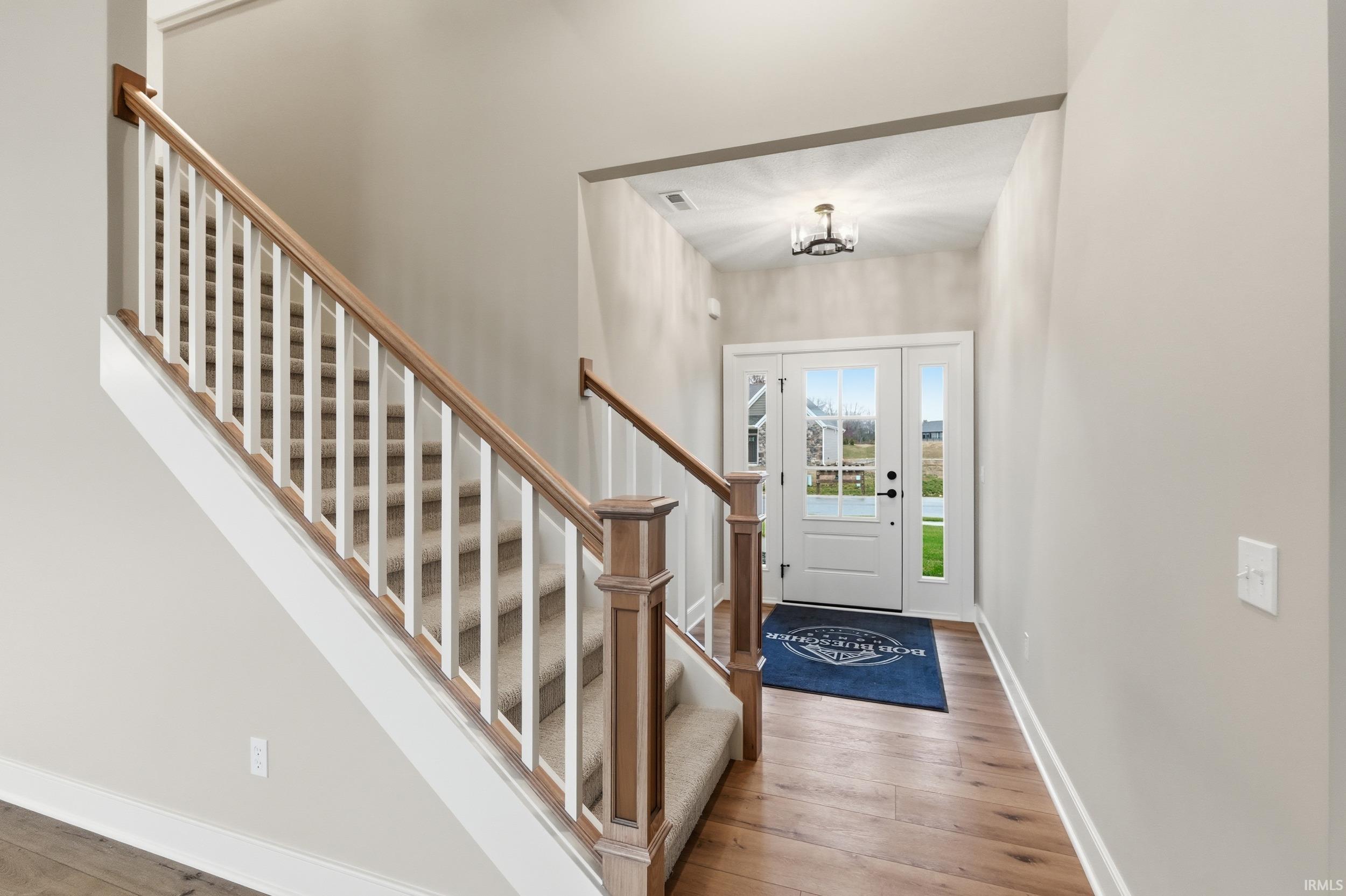 Foyer featuring light wood finished floors and stairs