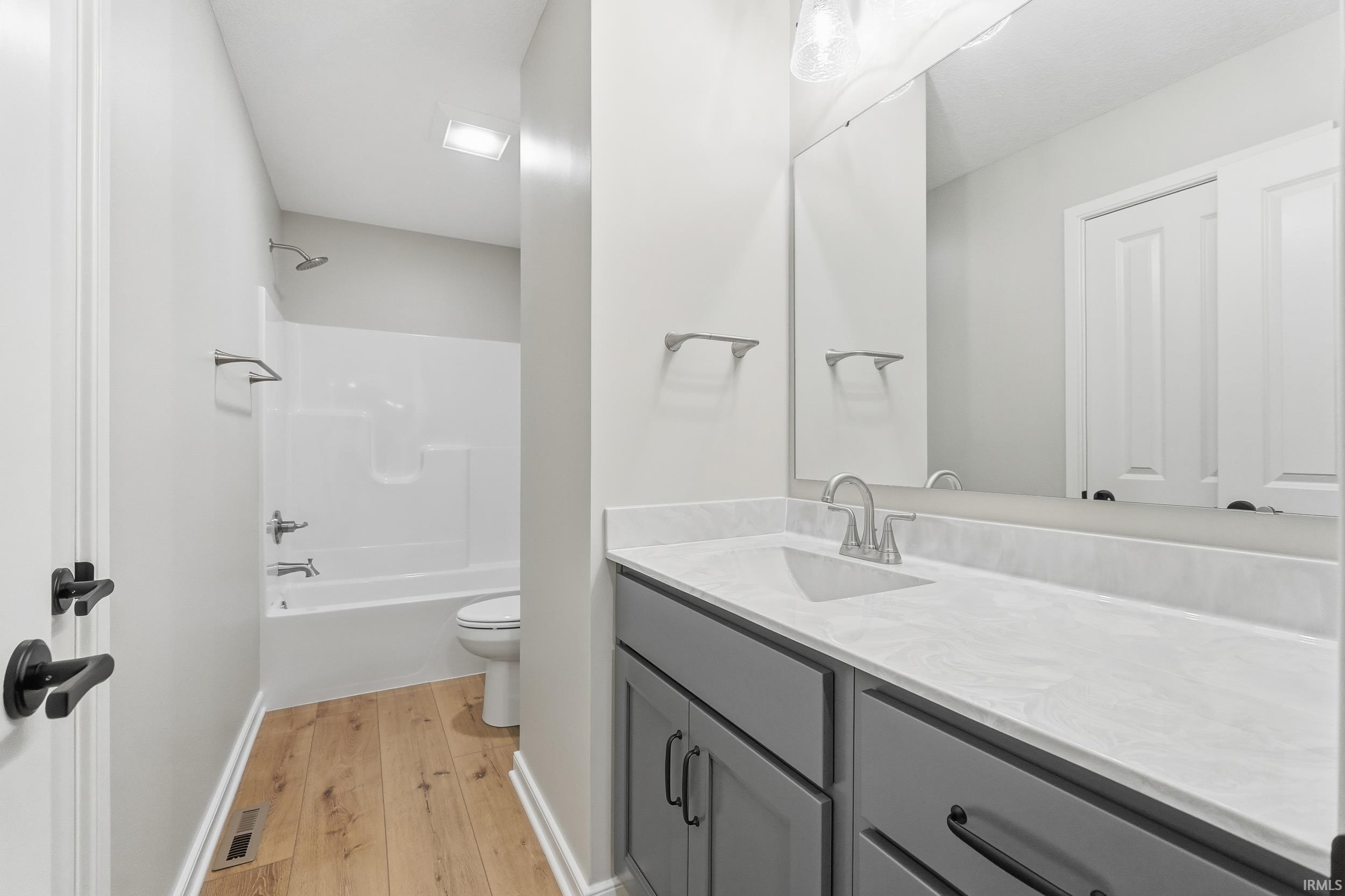 Bathroom featuring vanity, light wood-style floors, and tub / shower combination