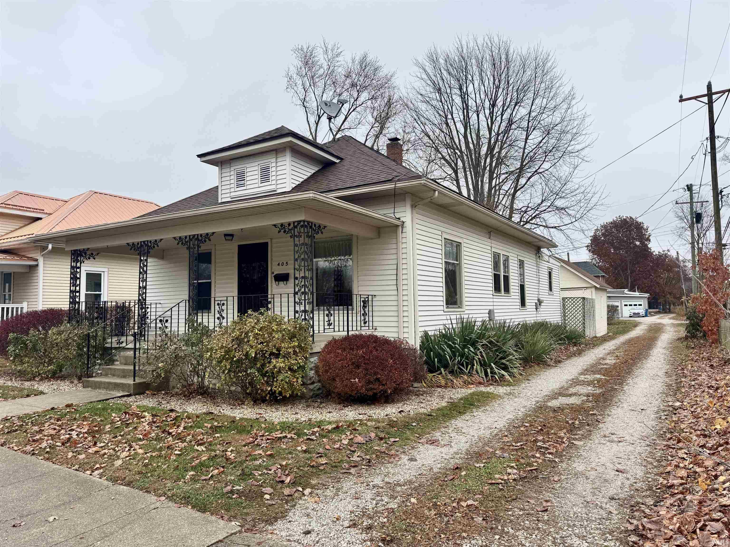 Bungalow featuring a porch, a chimney, and roof with shingles