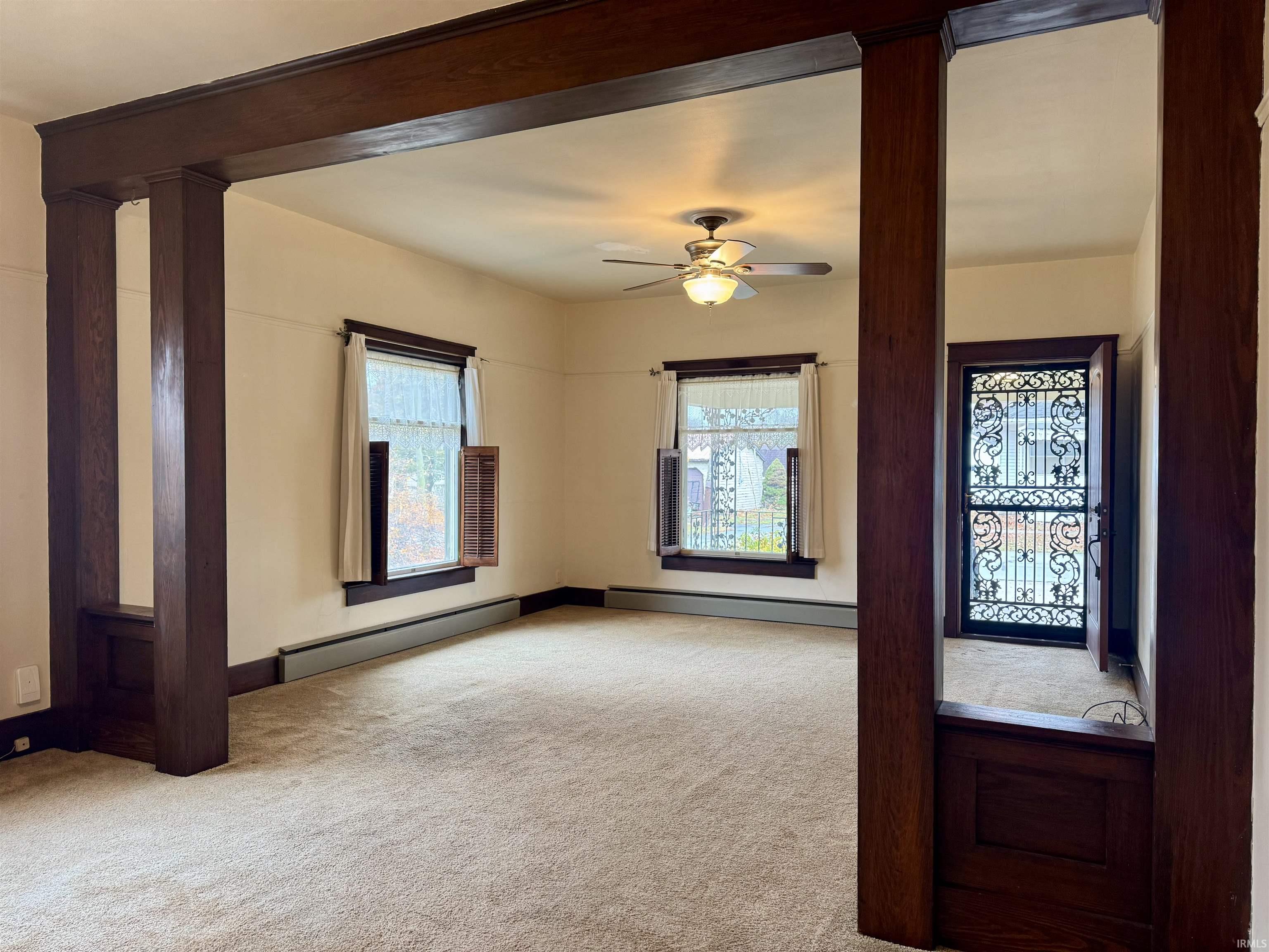 Entryway with a baseboard radiator, light colored carpet, and ceiling fan