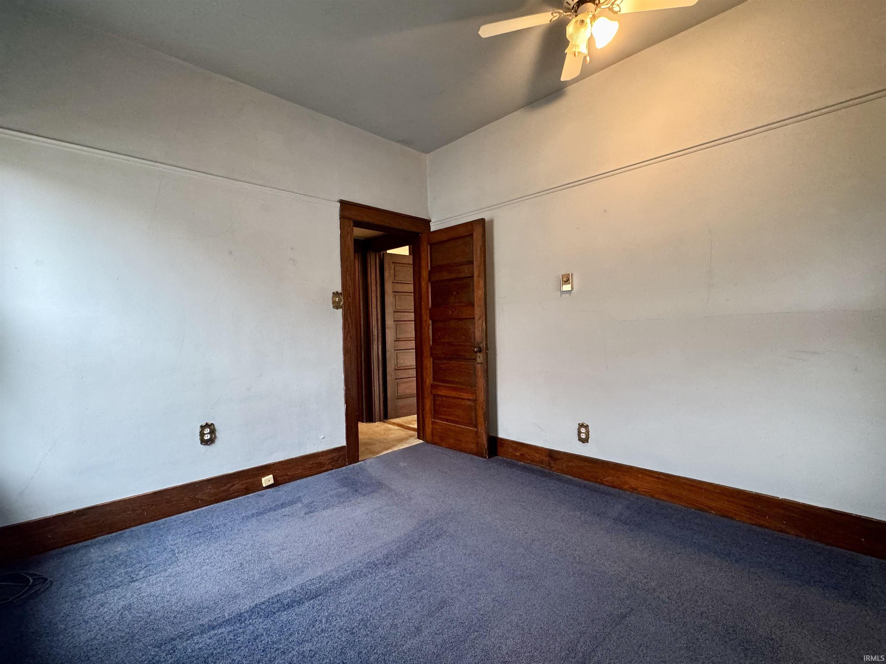 Empty room featuring carpet flooring and ceiling fan