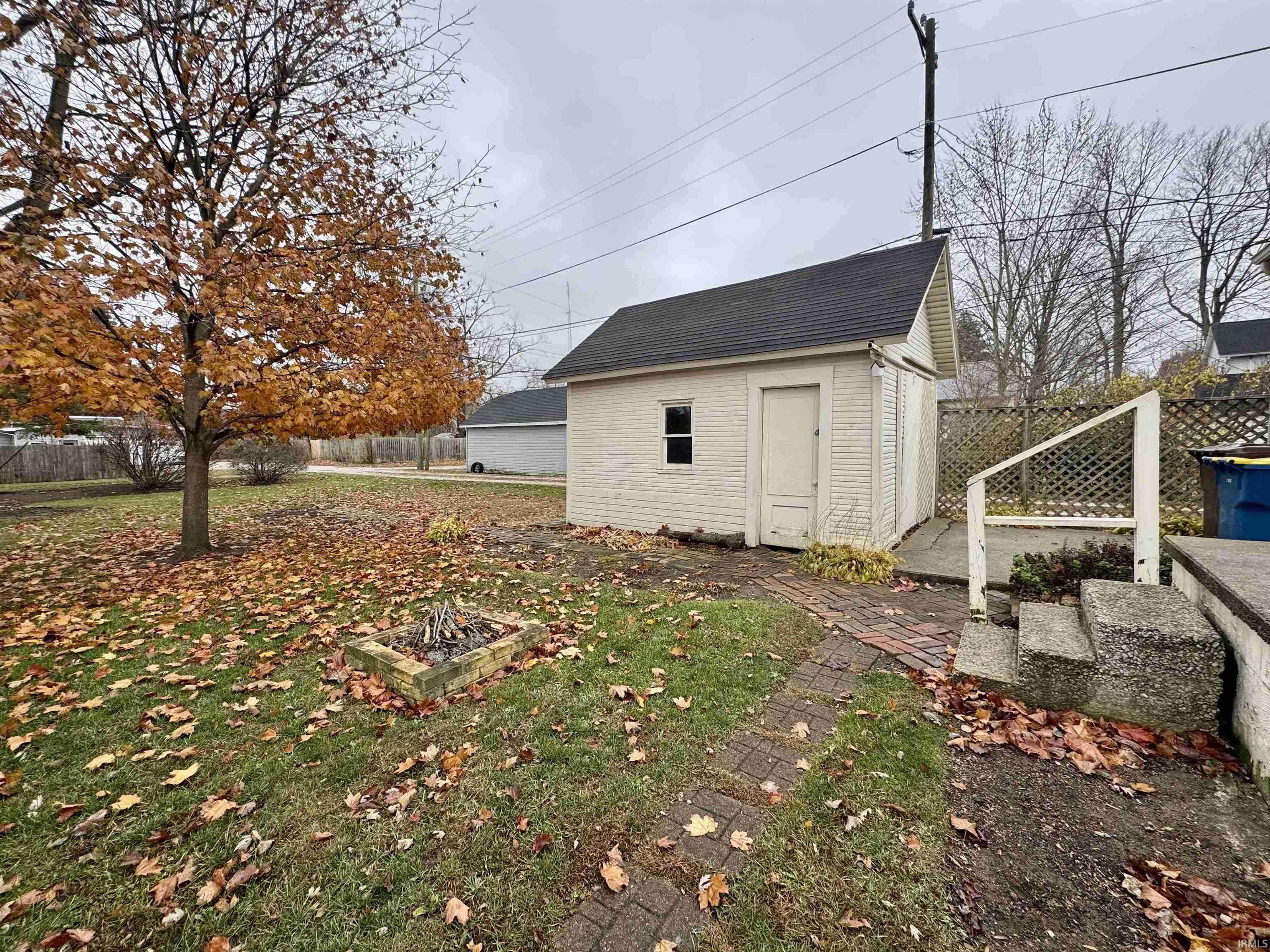 Fenced backyard featuring an outbuilding and an outdoor fire pit