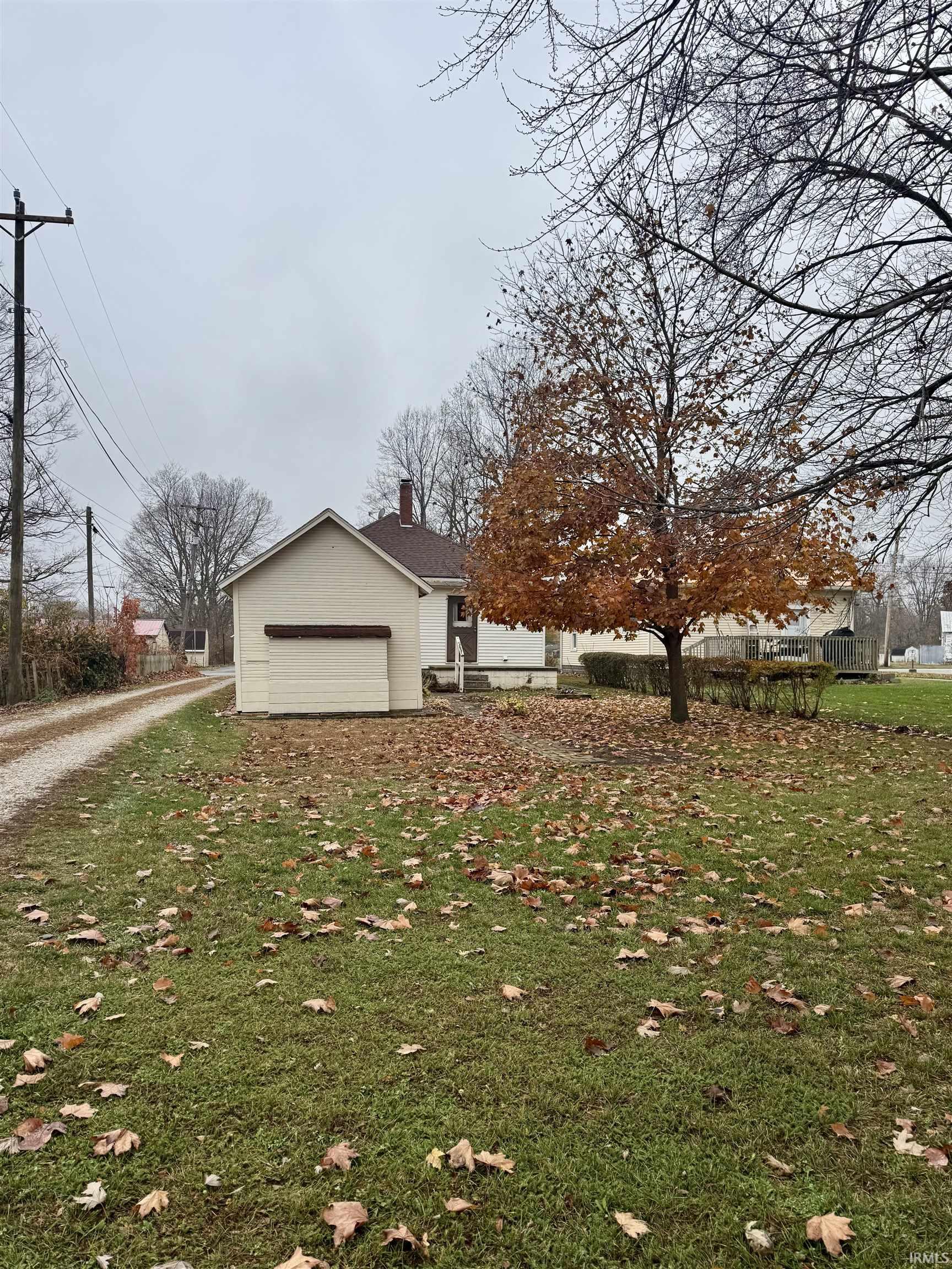 View of side of home featuring a chimney, an attached garage, and driveway