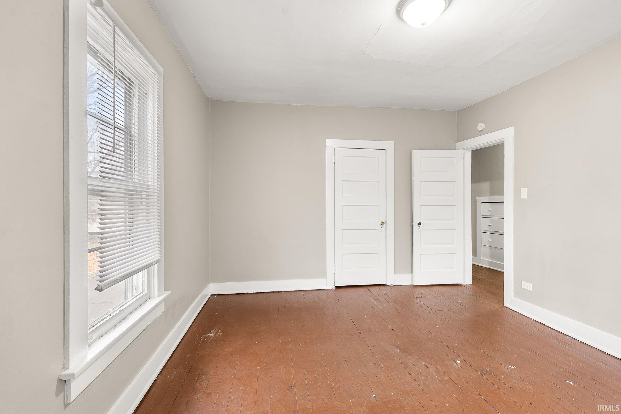 Unfurnished bedroom featuring a closet and hardwood / wood-style flooring