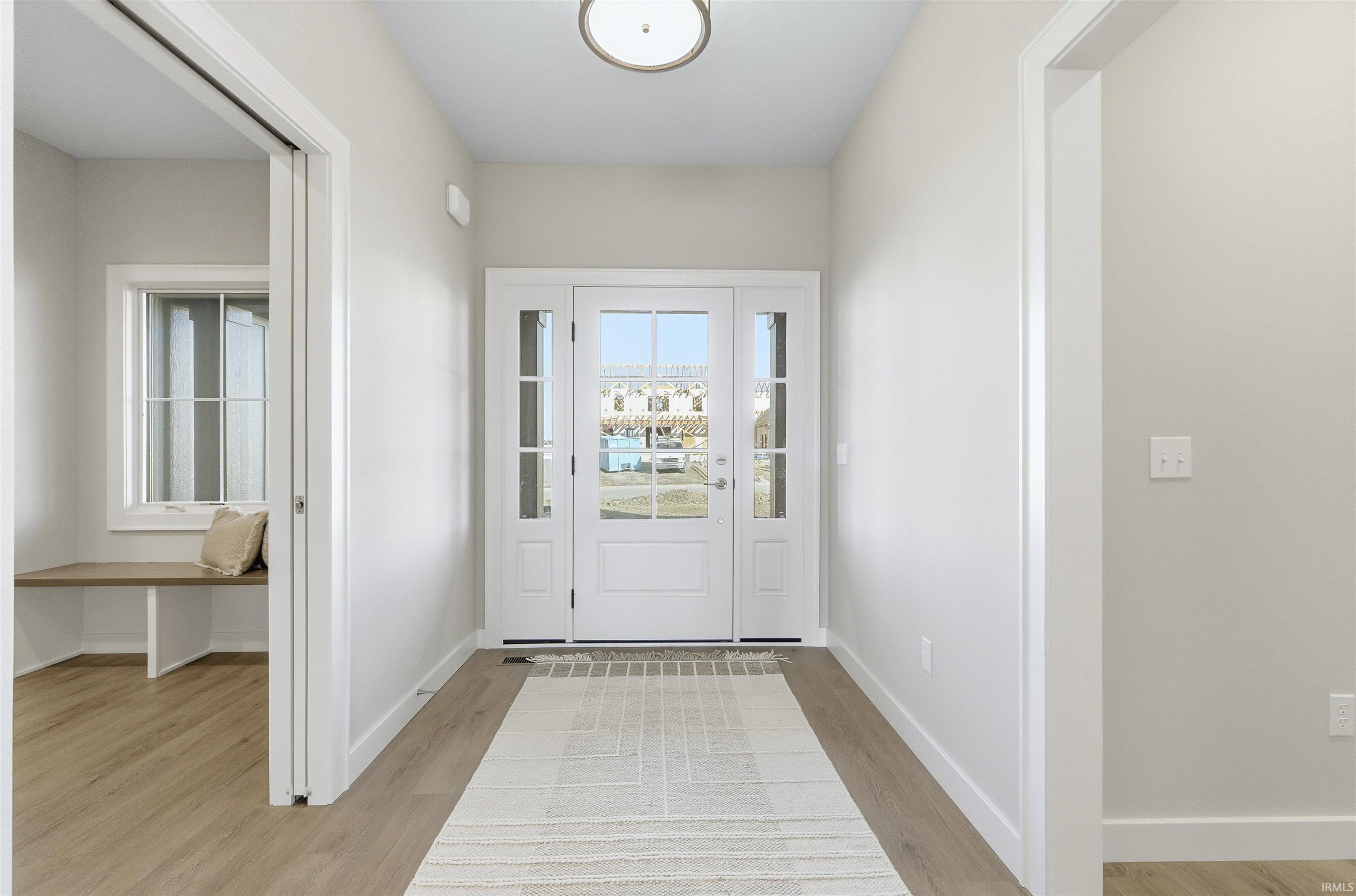 Entryway with wood finished floors and baseboards