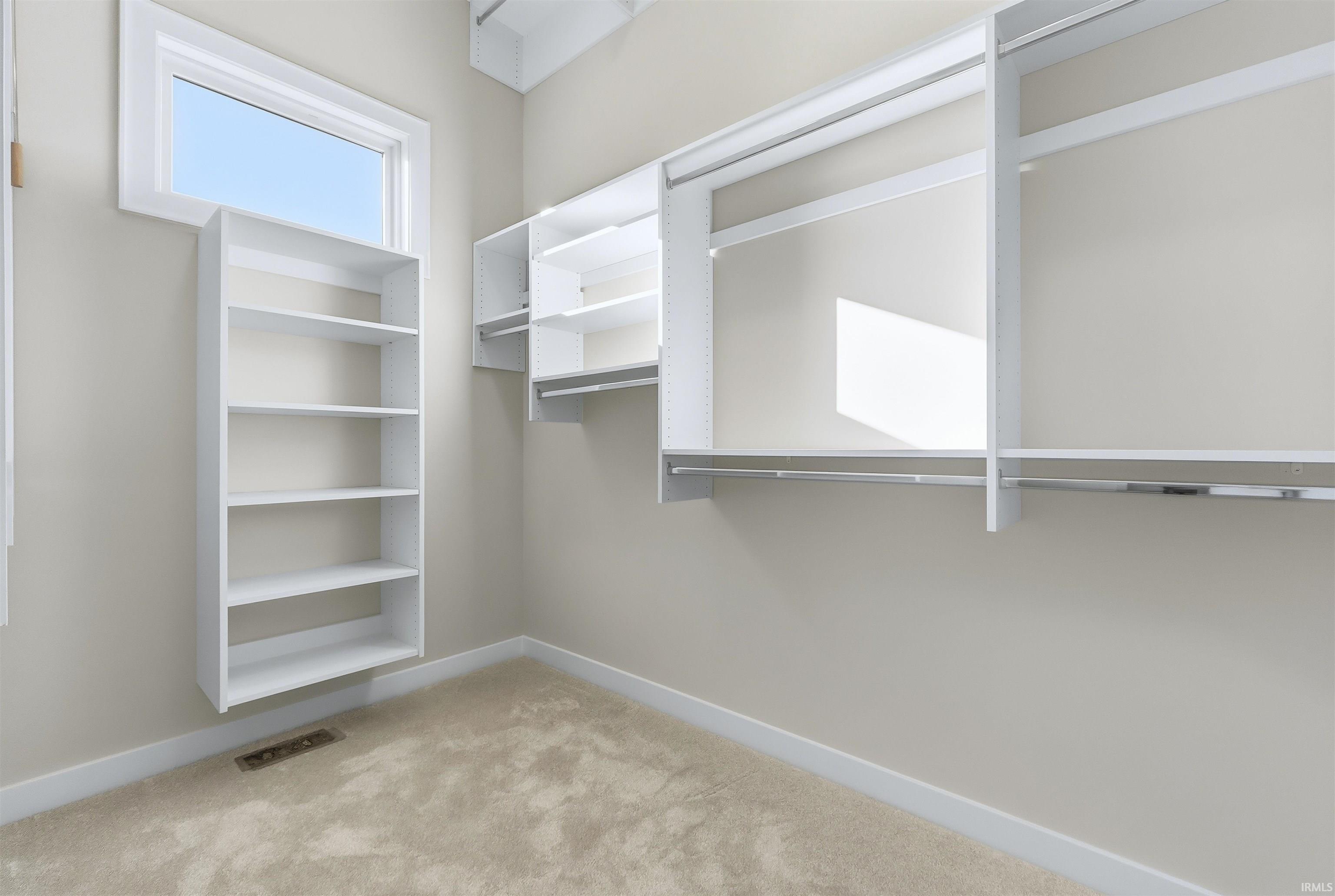 Spacious closet with light colored carpet