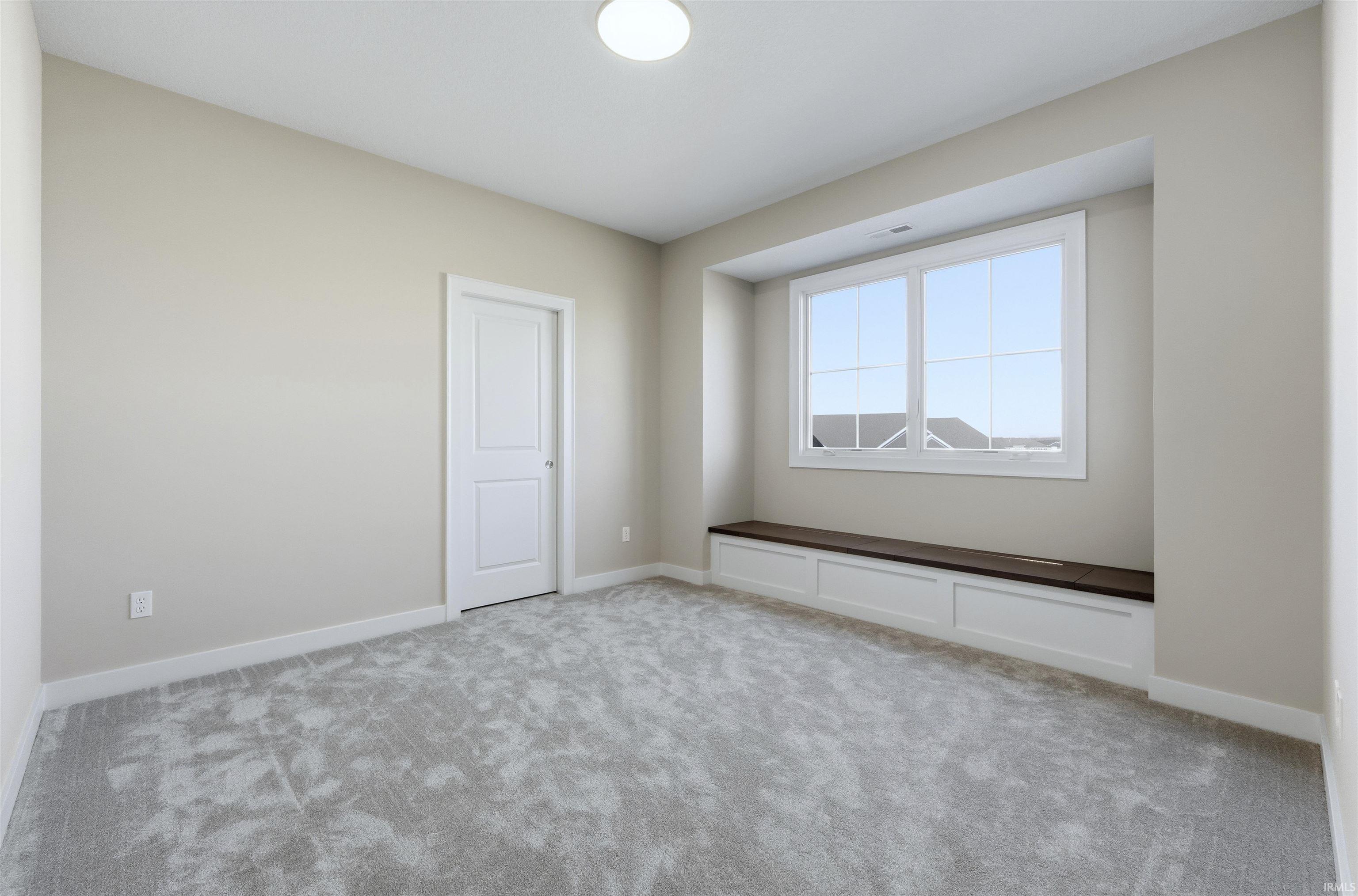 Empty room with light carpet and baseboards