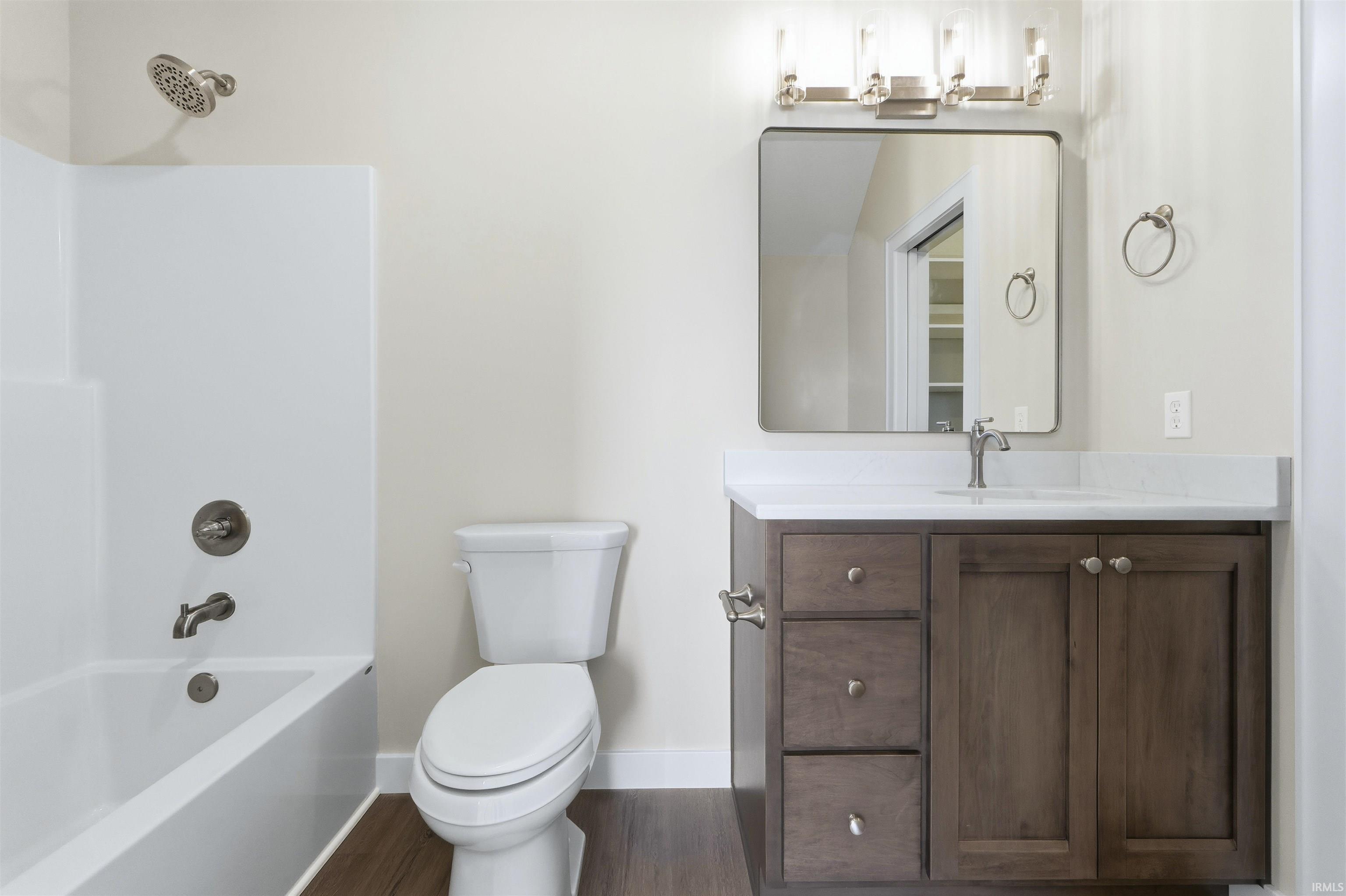 Bathroom with vanity, bathtub / shower combination, and dark wood finished floors