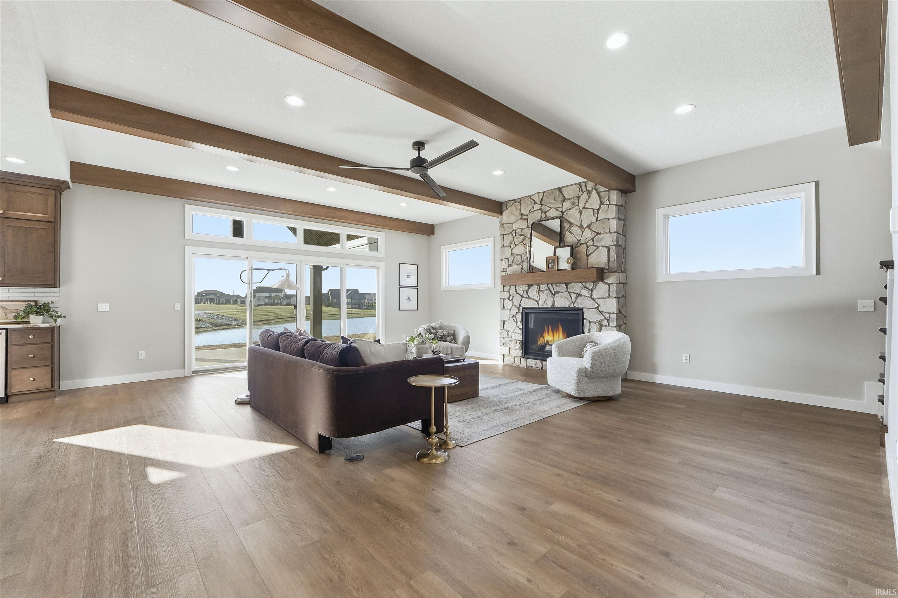 Living area featuring ceiling fan, healthy amount of natural light, a fireplace, light wood-style floors, and recessed lighting