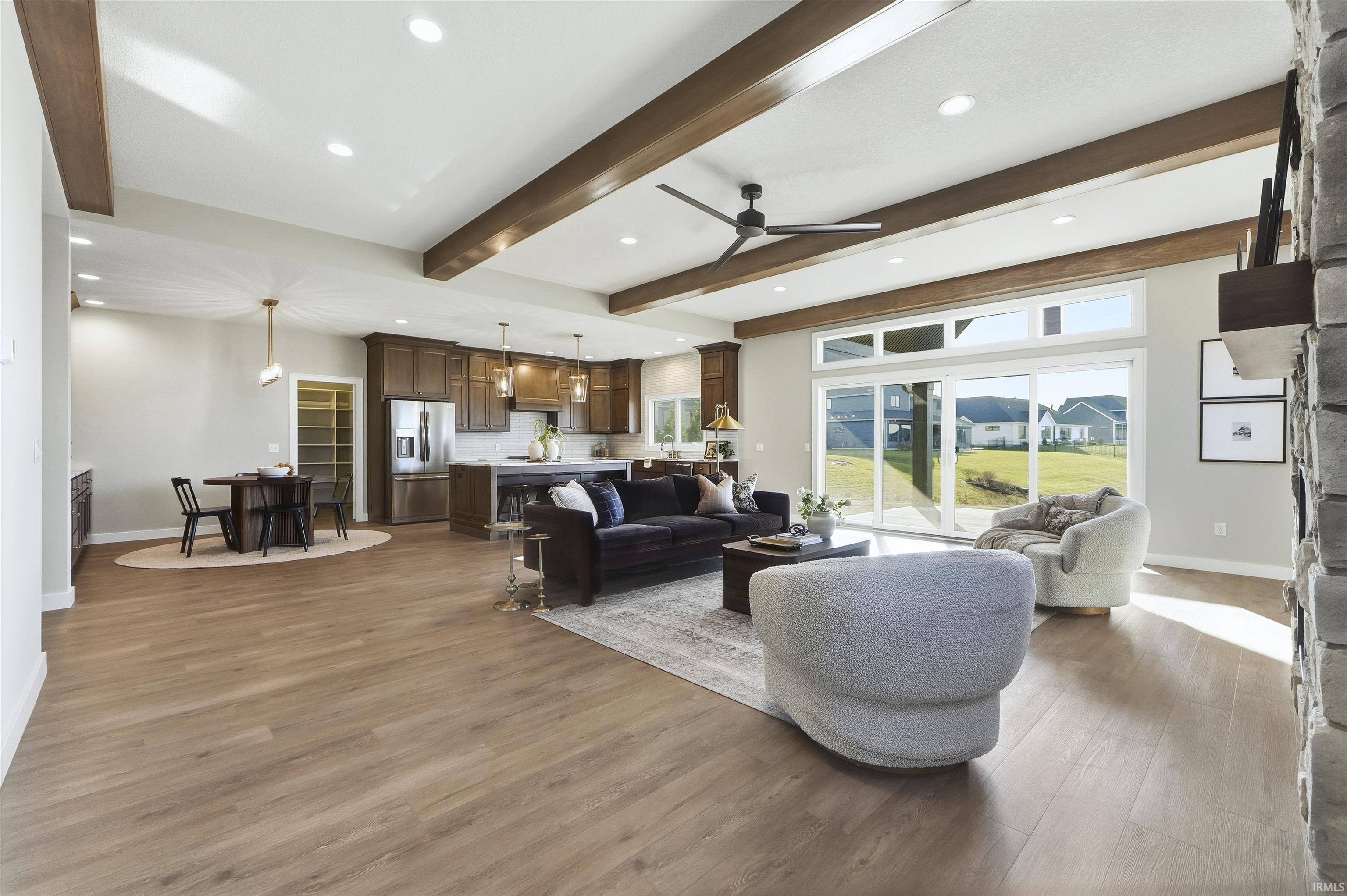 Living area featuring ceiling fan, recessed lighting, light wood-type flooring, and beam ceiling