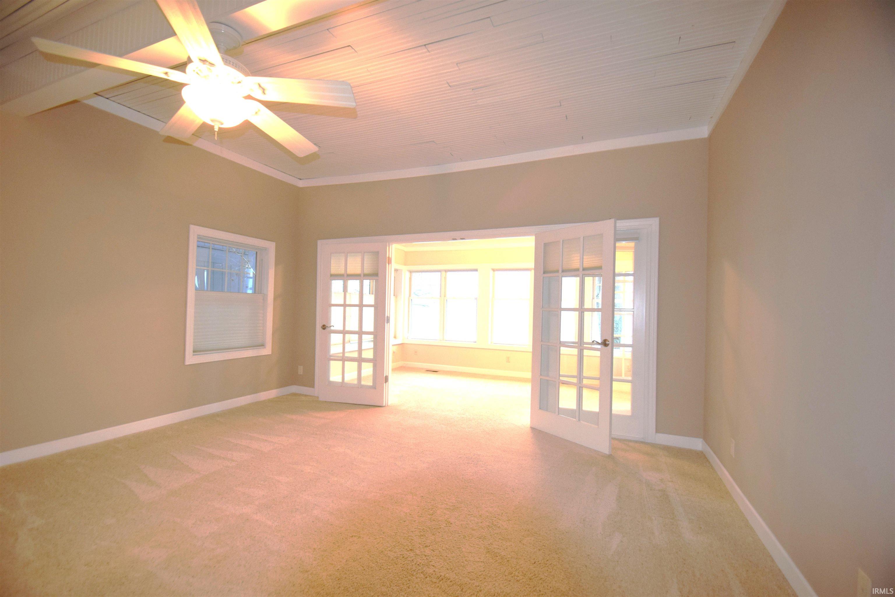 Spare room with french doors, light carpet, a ceiling fan, crown molding, and wood ceiling
