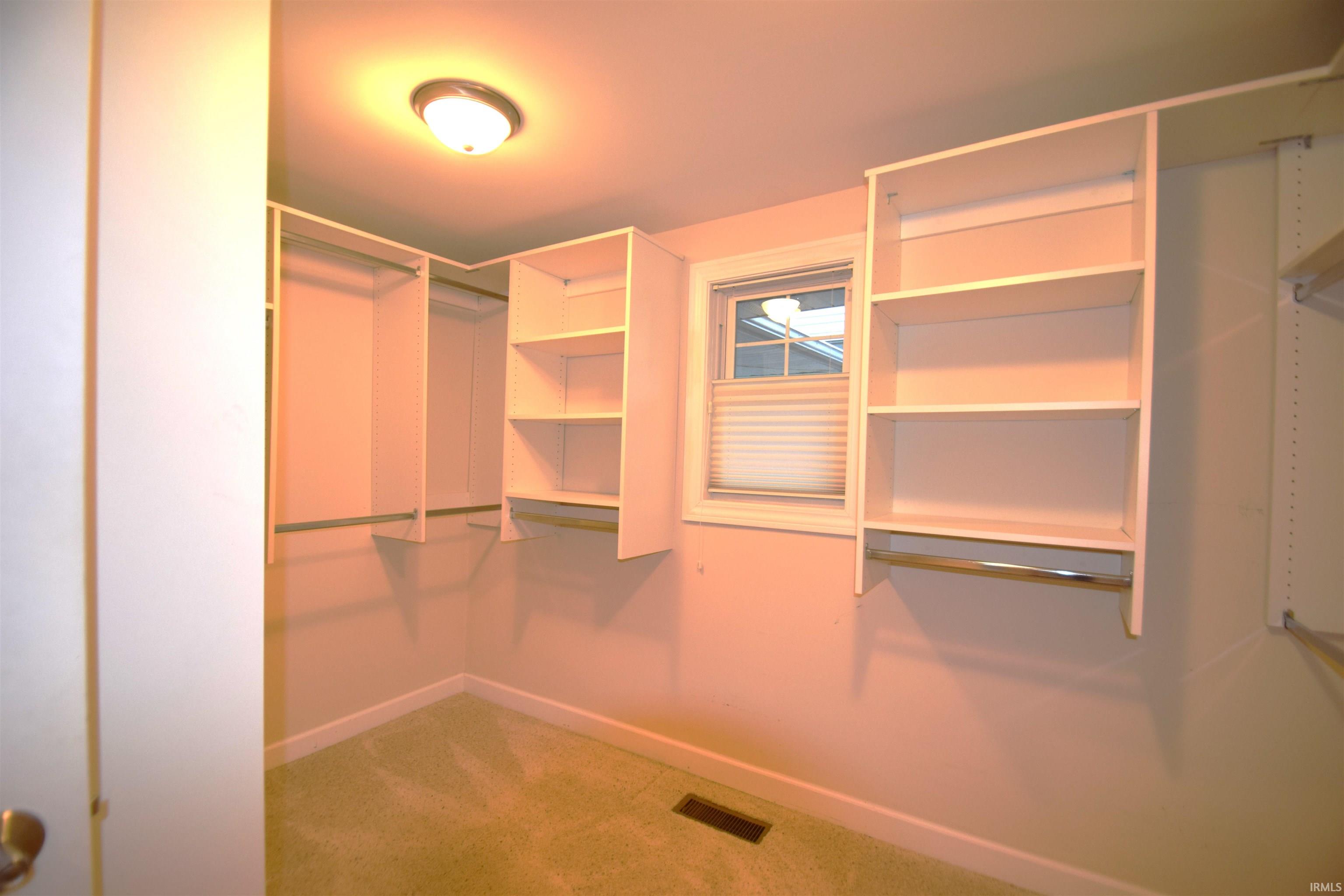 Spacious closet with light colored carpet
