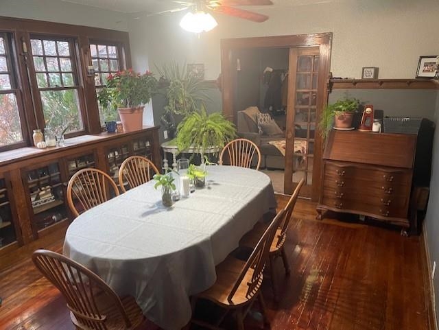 Dining room with dark wood-style flooring and a ceiling fan