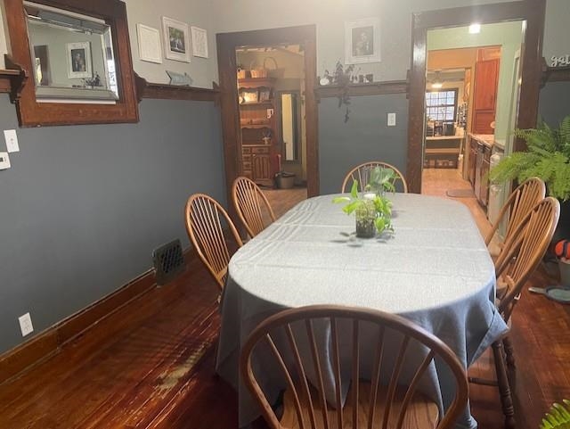 Dining area with dark wood finished floors and baseboards