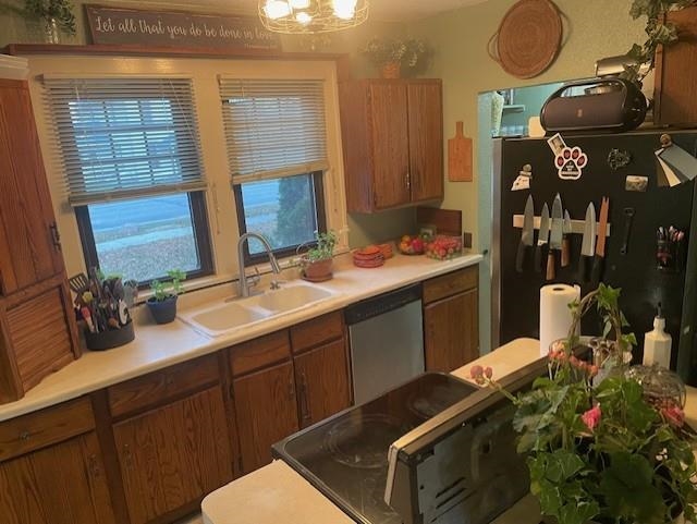 Kitchen featuring brown cabinetry, light countertops, and stainless steel appliances