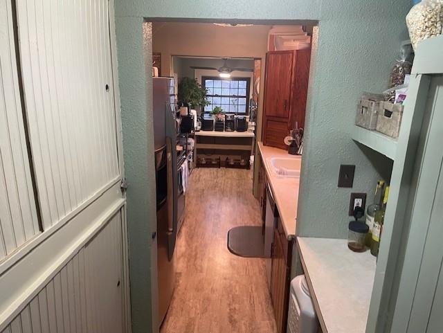 Bathroom featuring a textured wall, vanity, and light wood-type flooring