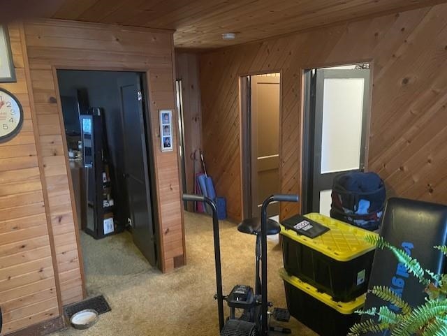 Bedroom featuring wooden walls, wood ceiling, and light colored carpet