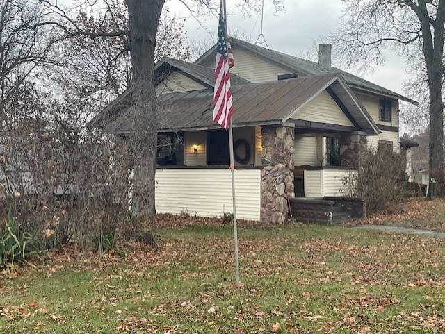 View of property exterior with a lawn and a chimney