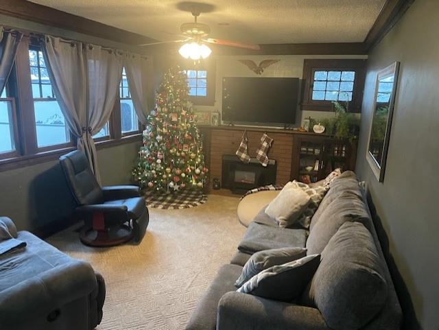 Carpeted living room with ceiling fan and a textured ceiling
