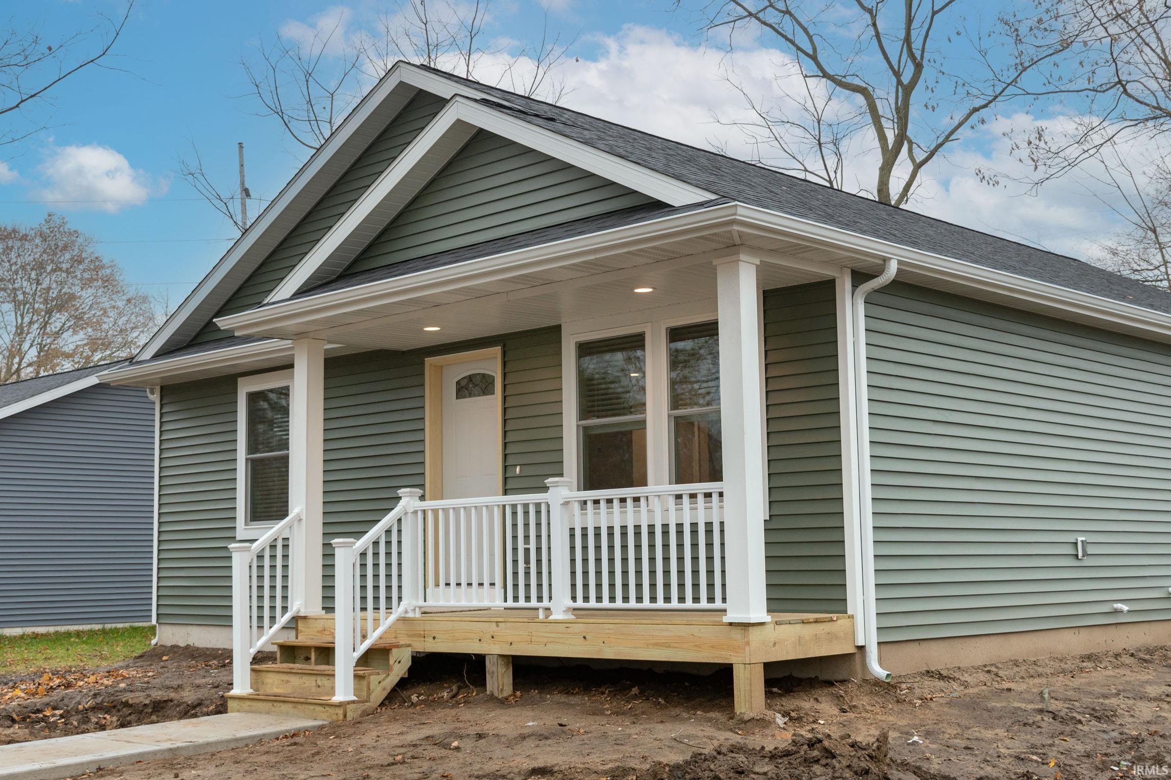 View of front of property with roof with shingles and covered porch