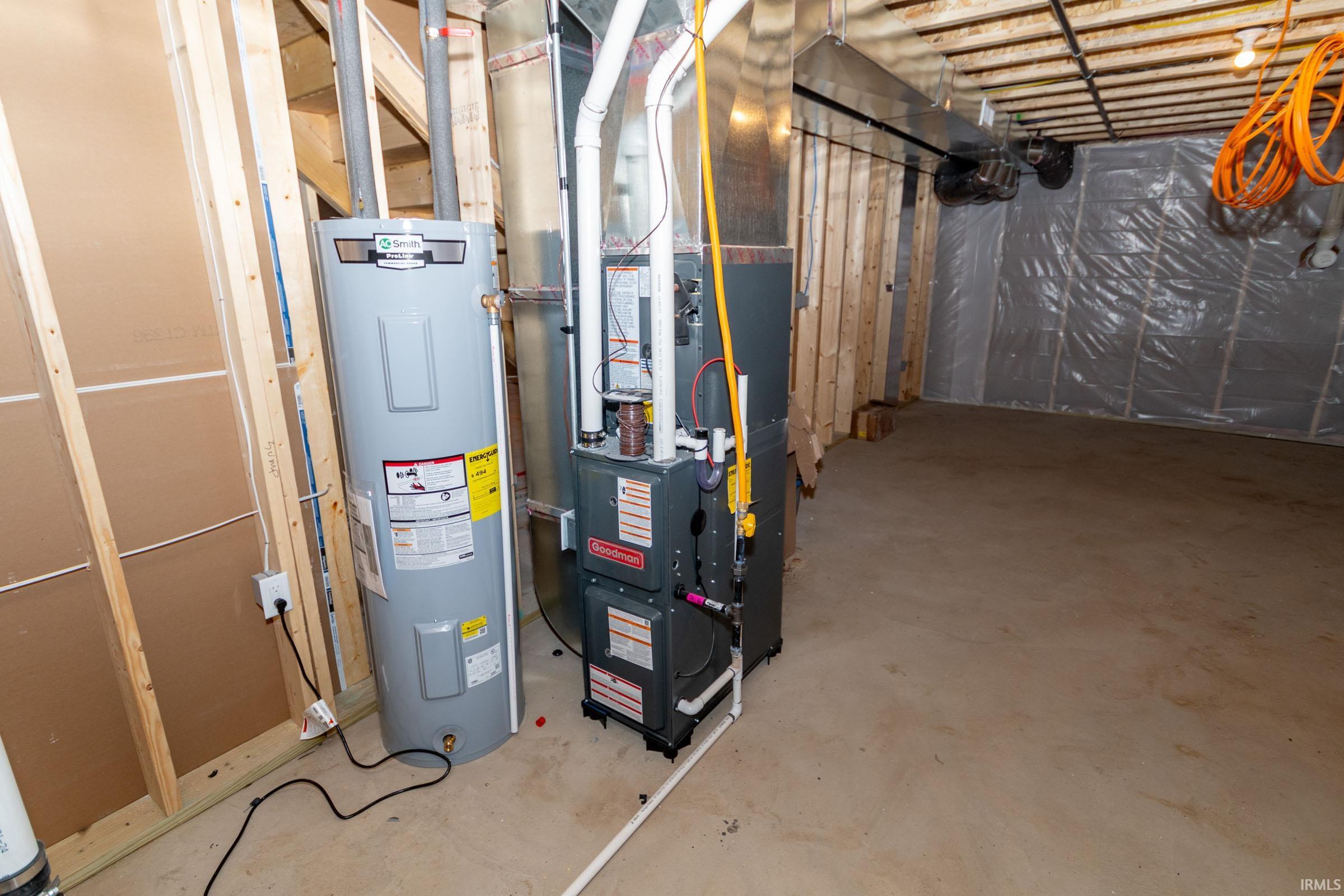 Utility room featuring water heater and heating unit