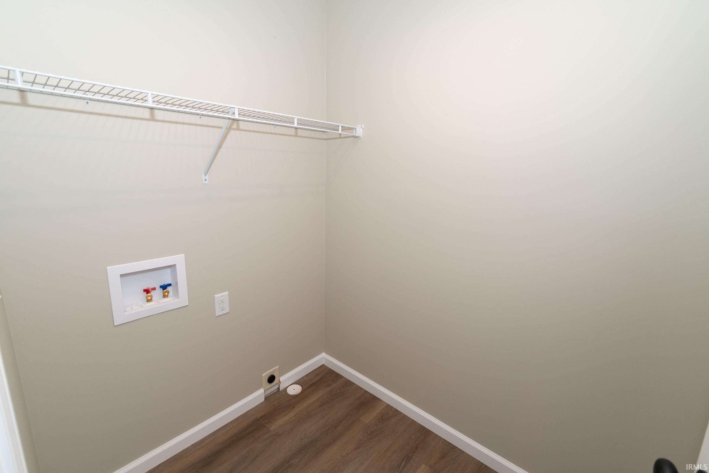Laundry area featuring dark wood-style flooring, hookup for a washing machine, and electric dryer hookup