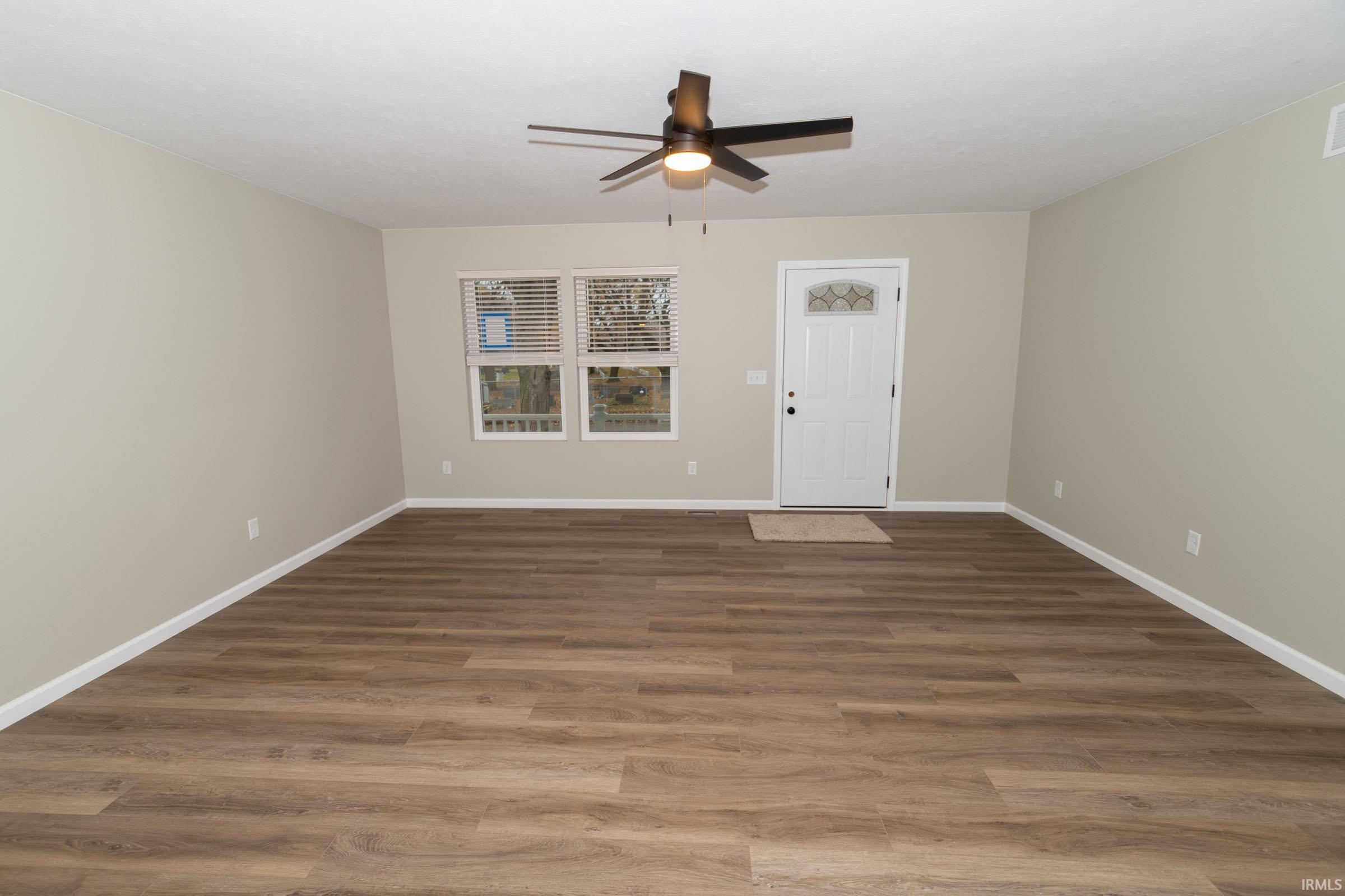 Spare room with dark wood finished floors and ceiling fan