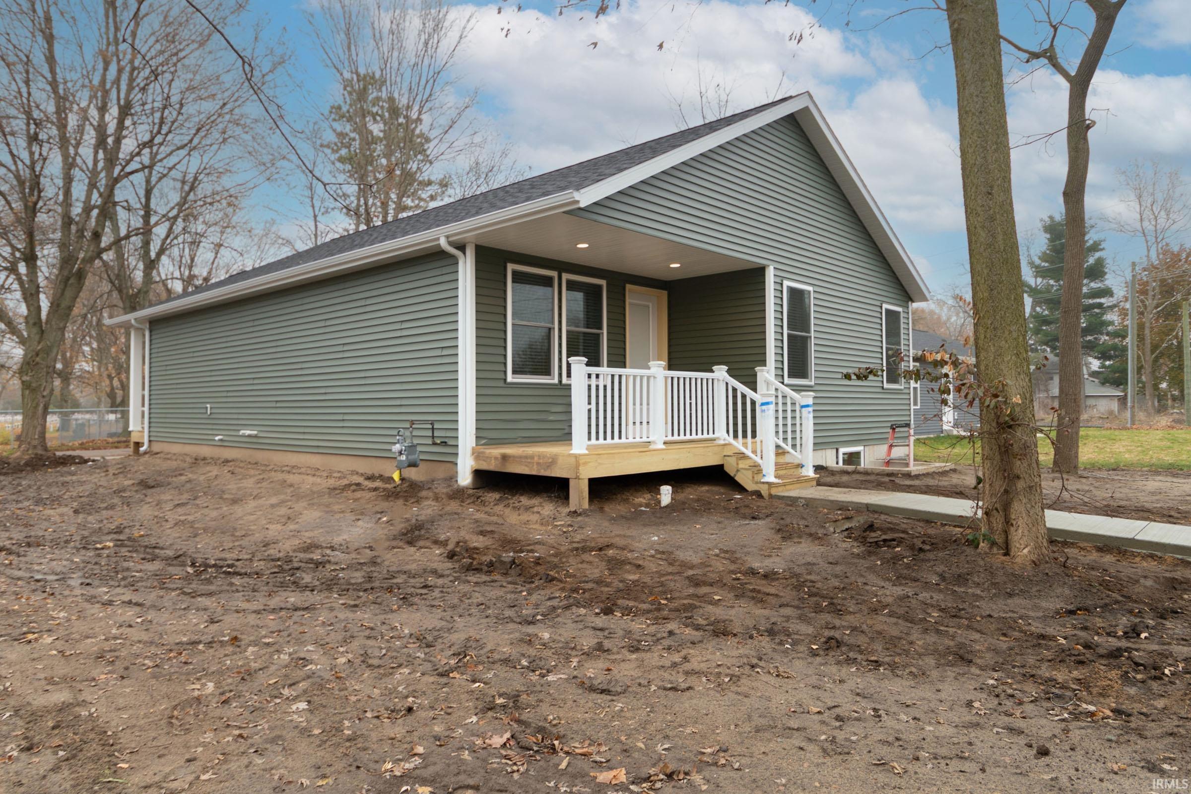 Rear view of house with a deck and a shingled roof