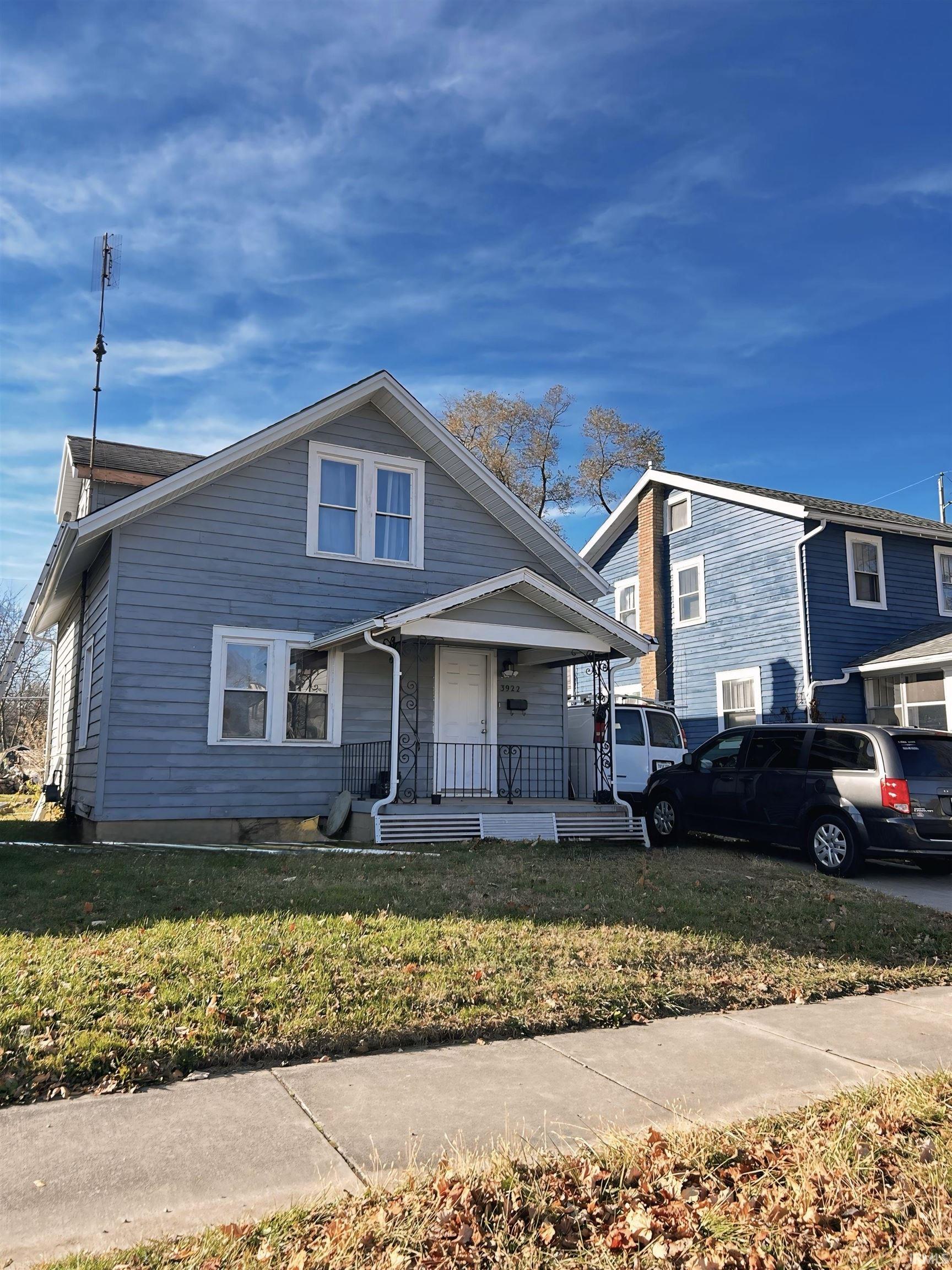 Bungalow with covered porch and a front yard