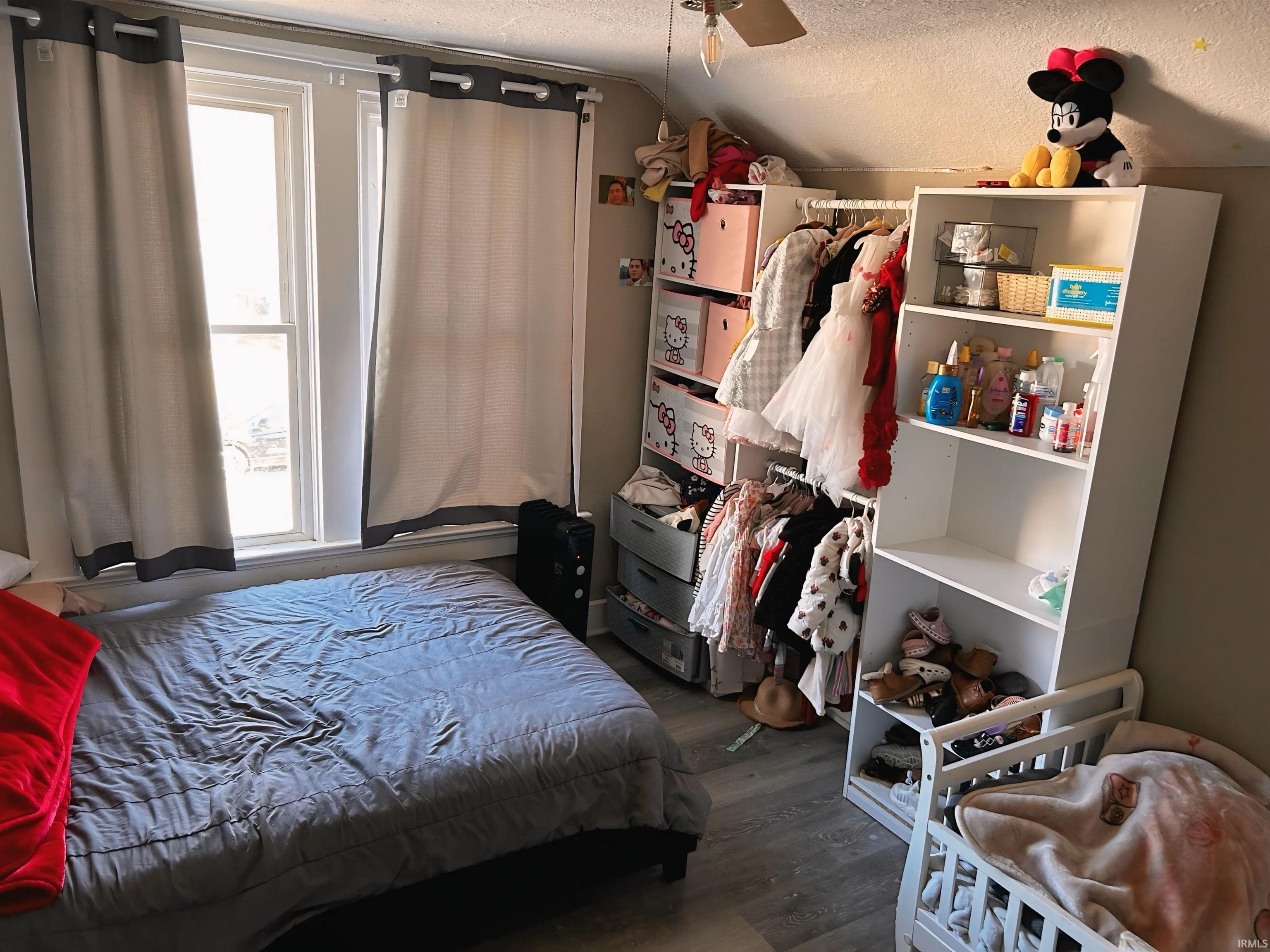 Bedroom featuring a textured ceiling, dark wood-type flooring, and vaulted ceiling