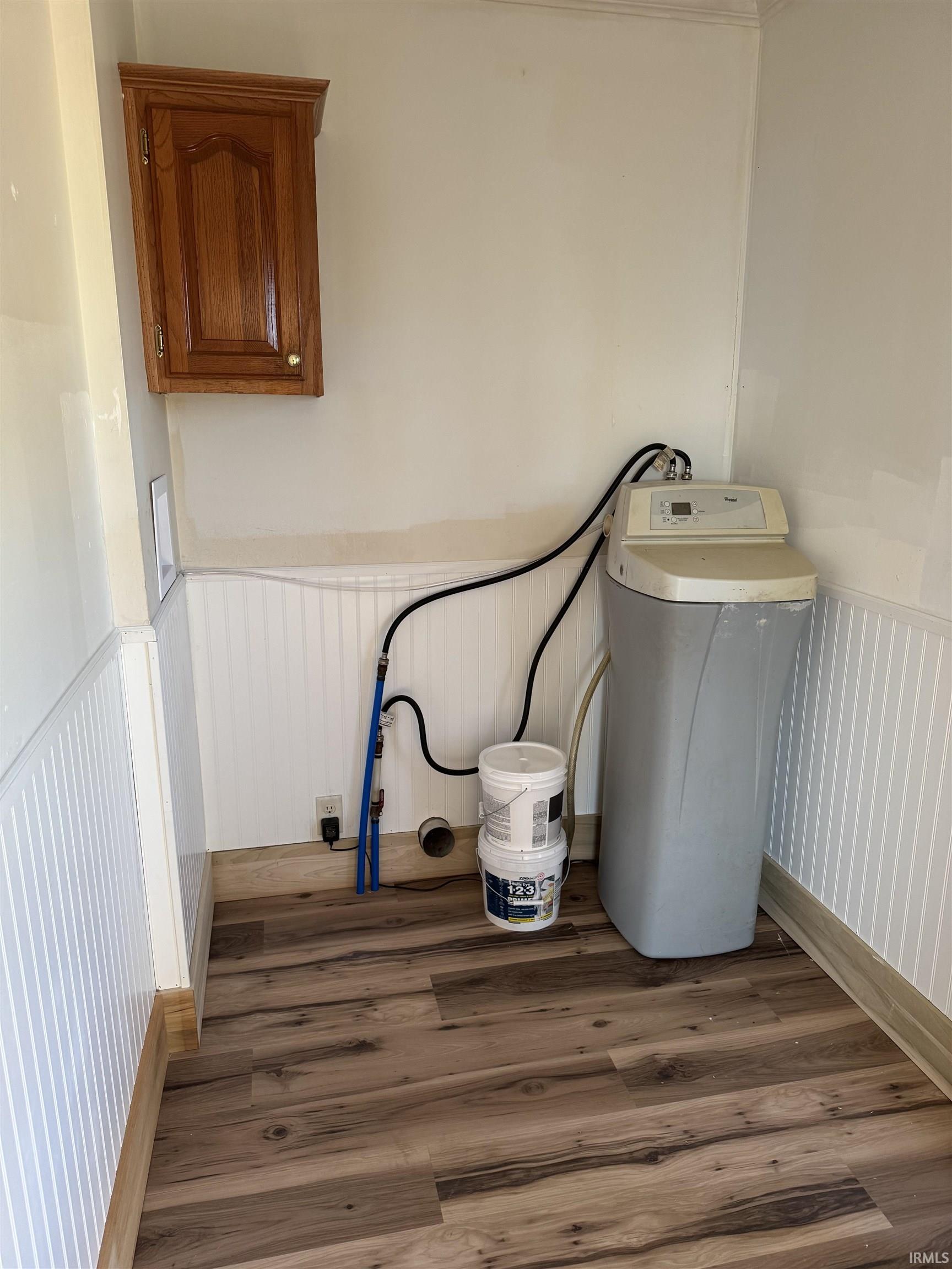 Washroom with wood finished floors and wainscoting
