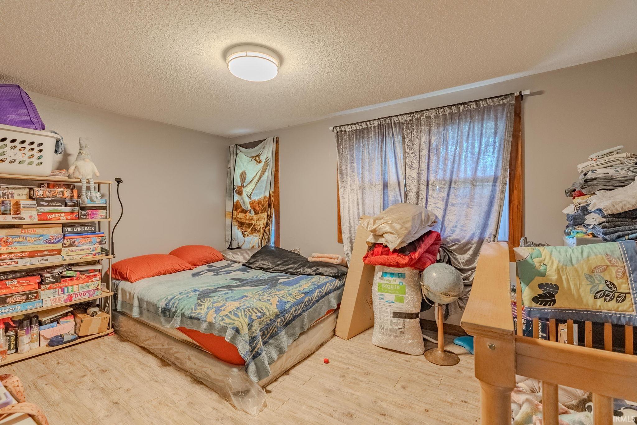 Bedroom with a textured ceiling and laminate floors