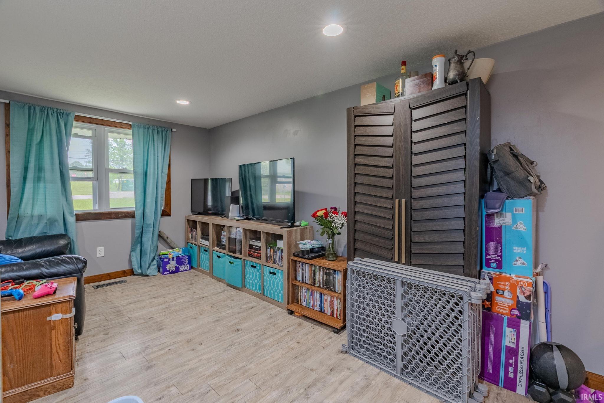 Game room featuring light wood-type laminate flooring and recessed lighting