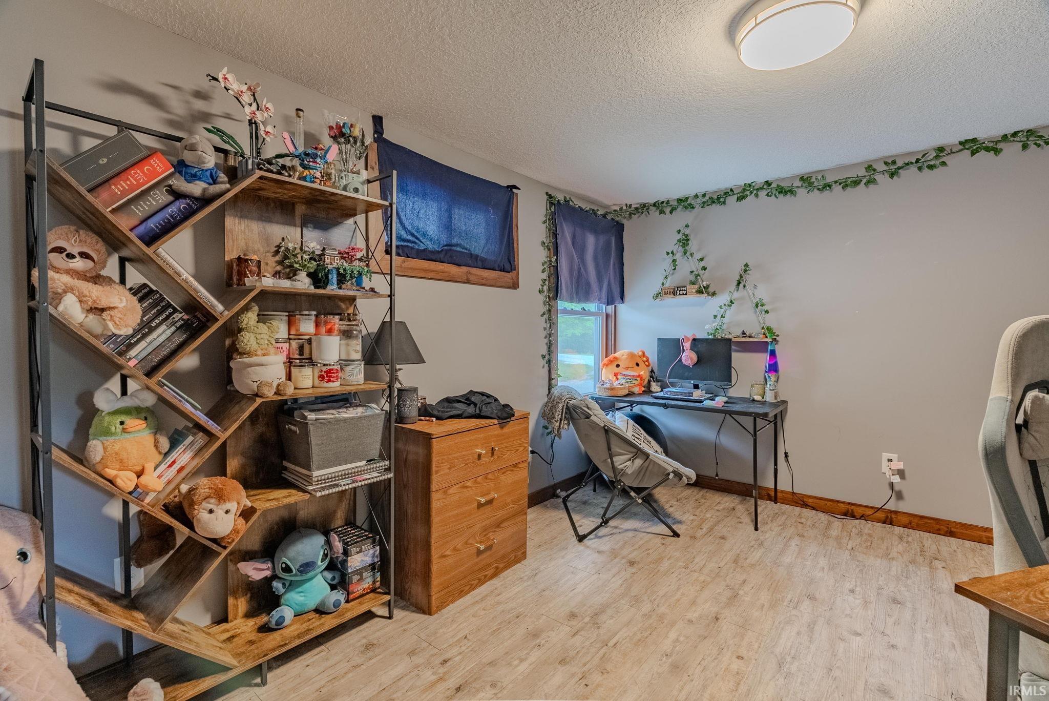 Office space with a textured ceiling and light laminate floors