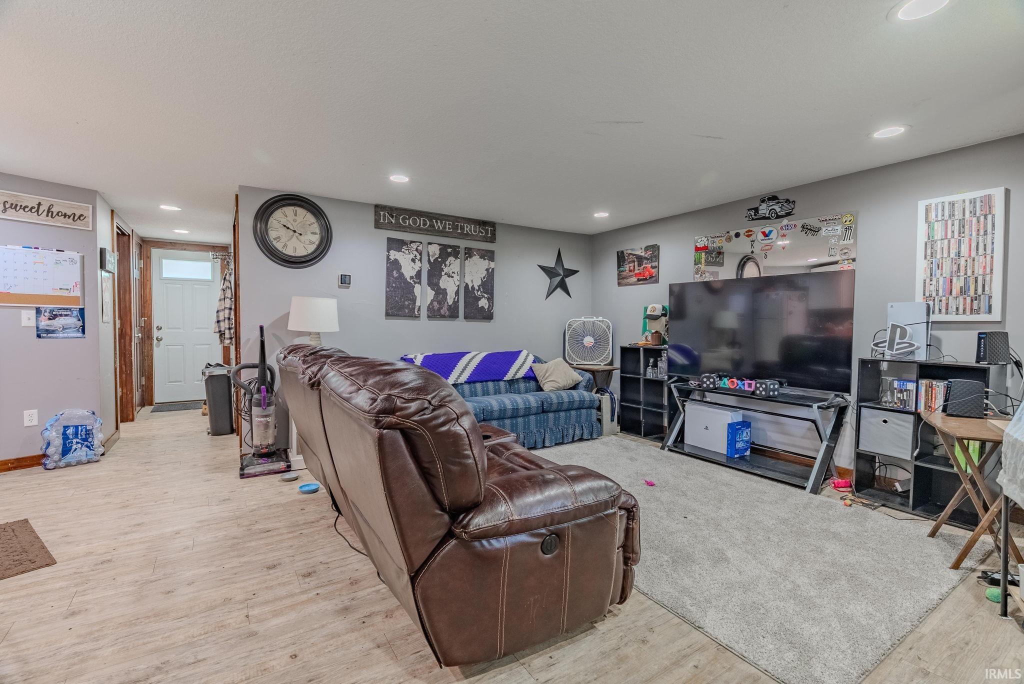 Living area featuring light laminate floors and recessed lighting