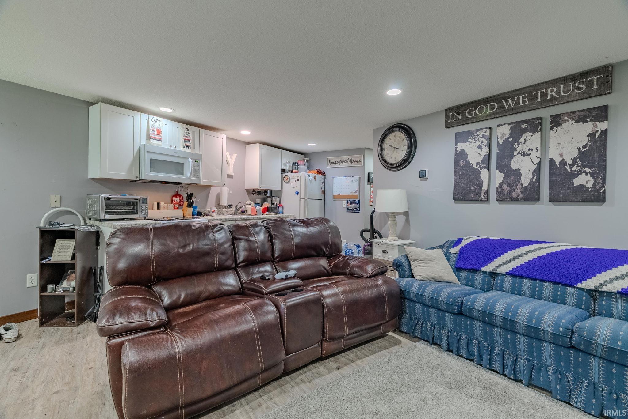 Living area featuring light wood-style laminate flooring and recessed lighting