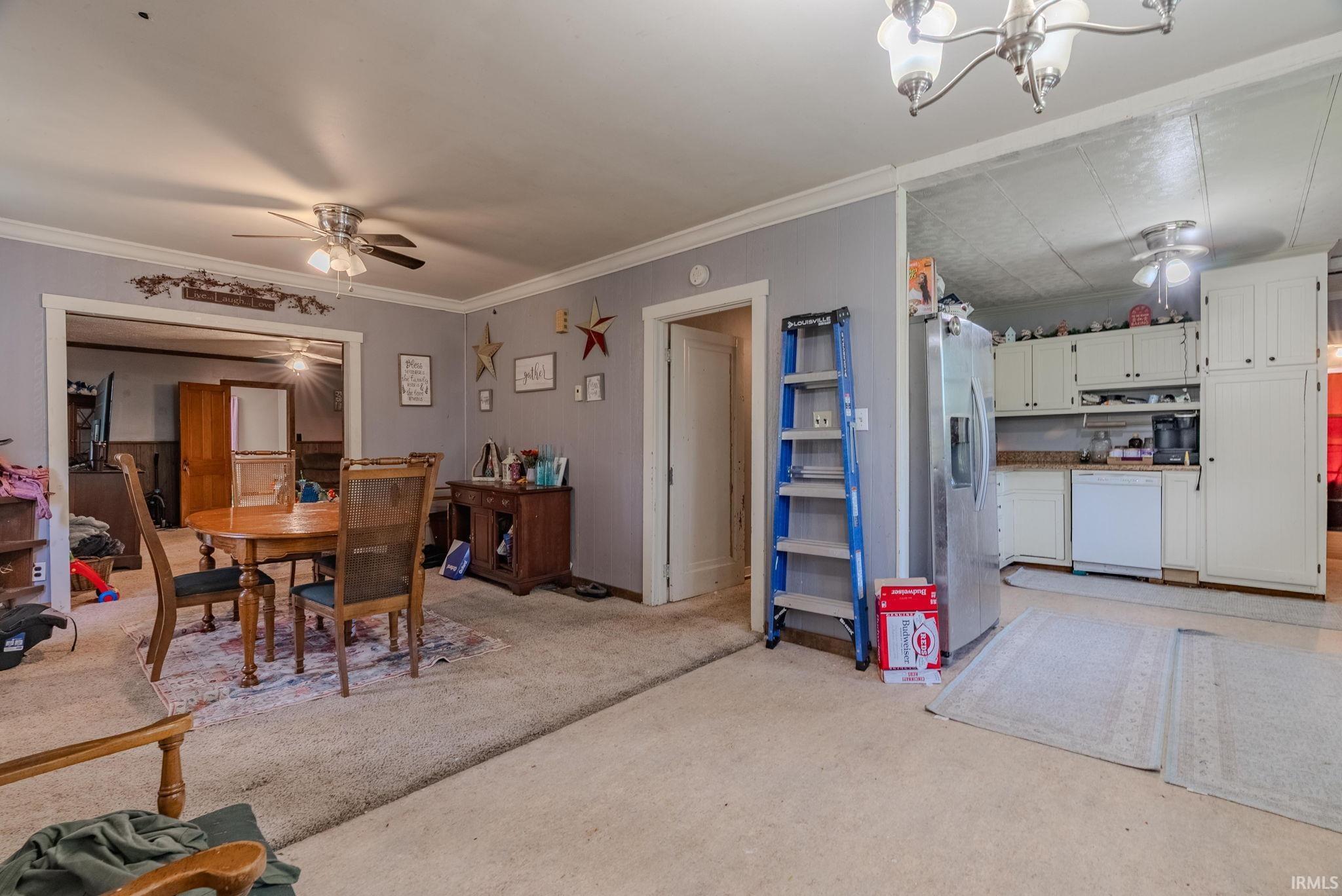 Dining area with a ceiling fan andornamental molding