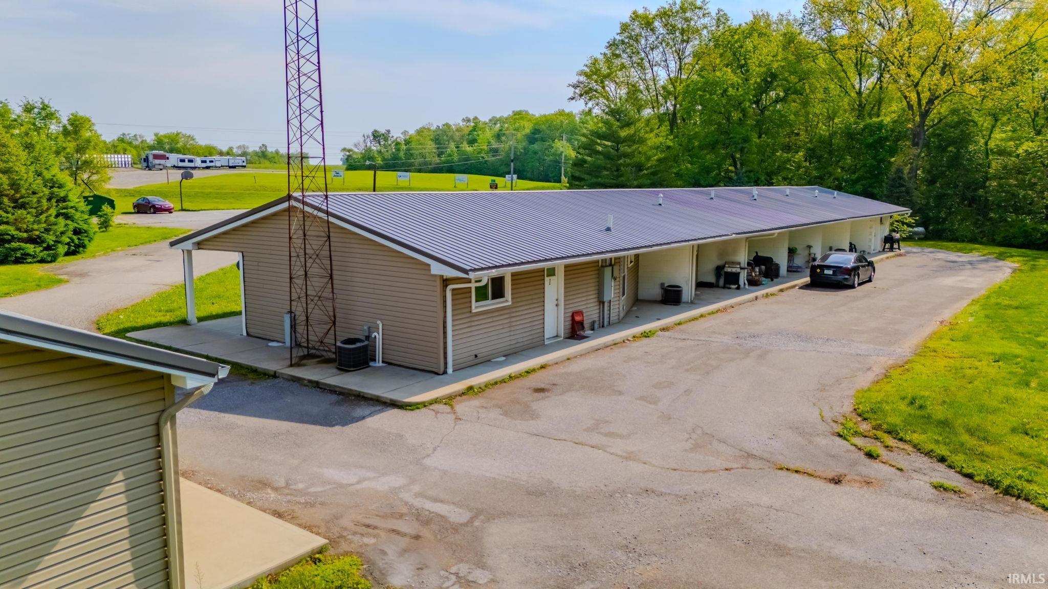 View of back of units featuring a metal roof and a back yard