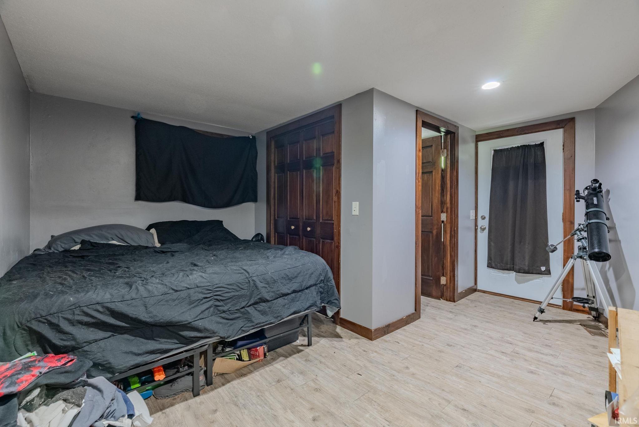 Bedroom with laminate floors and a closet