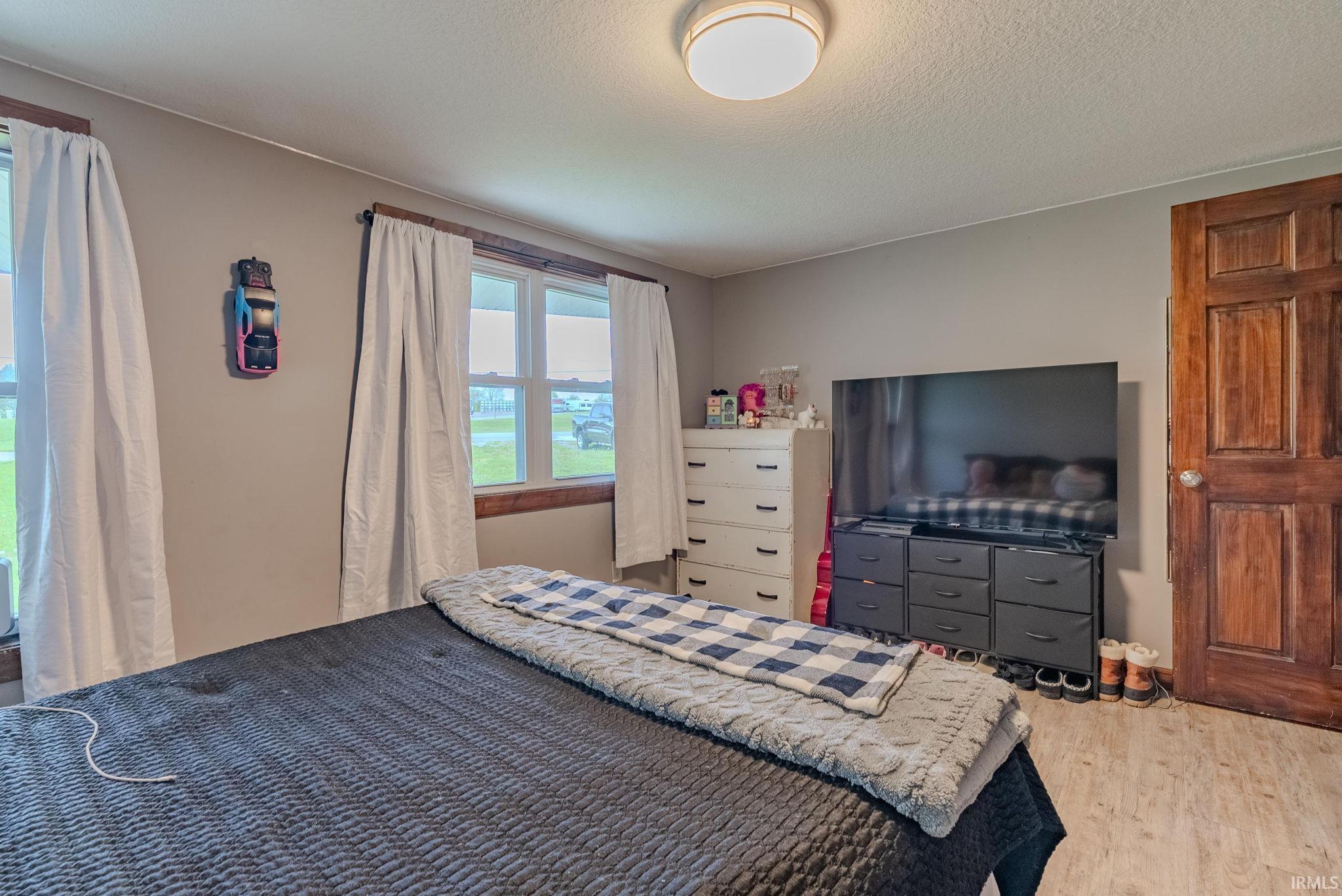 Bedroom featuring laminate floors and a textured ceiling
