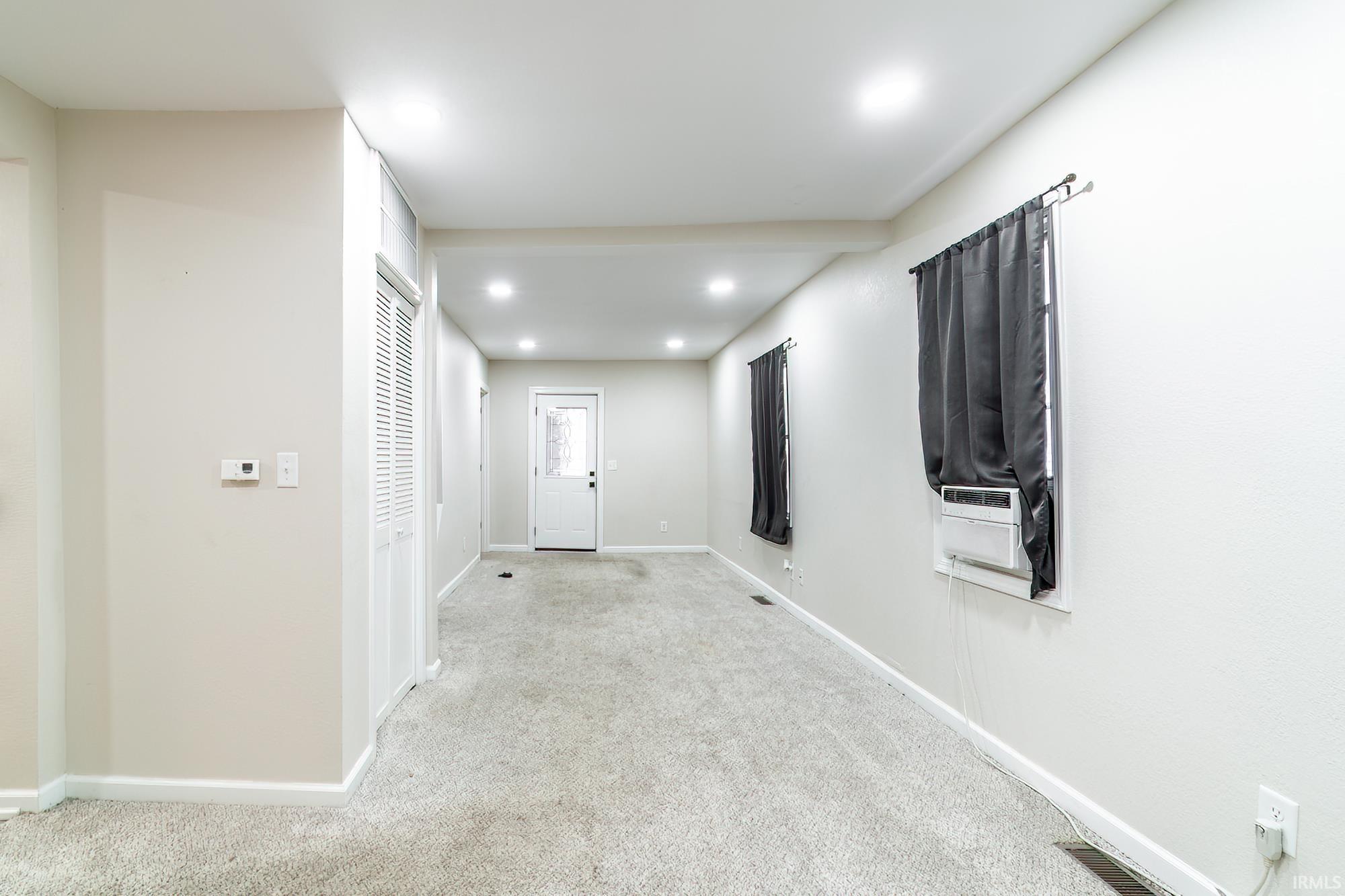 Hallway featuring carpet floors, recessed lighting, and cooling unit