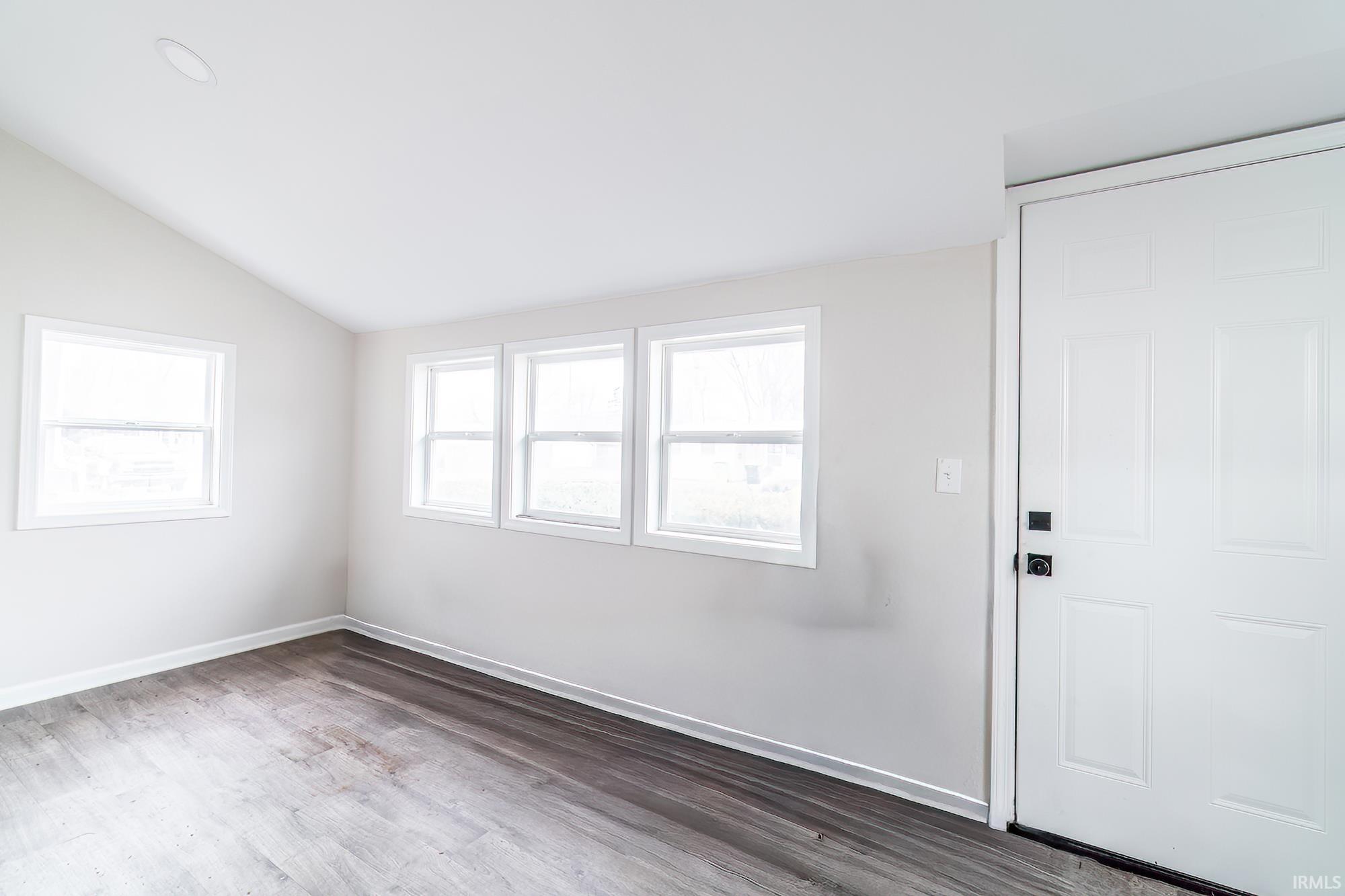 Foyer with vaulted ceiling and wood finished floors