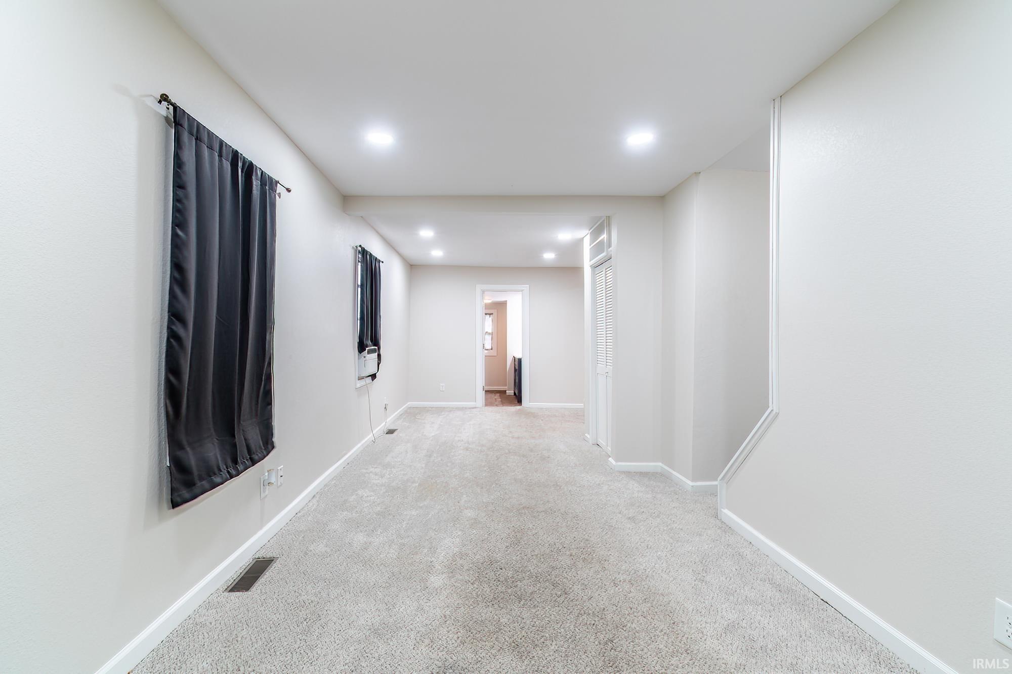 Corridor featuring recessed lighting and carpet