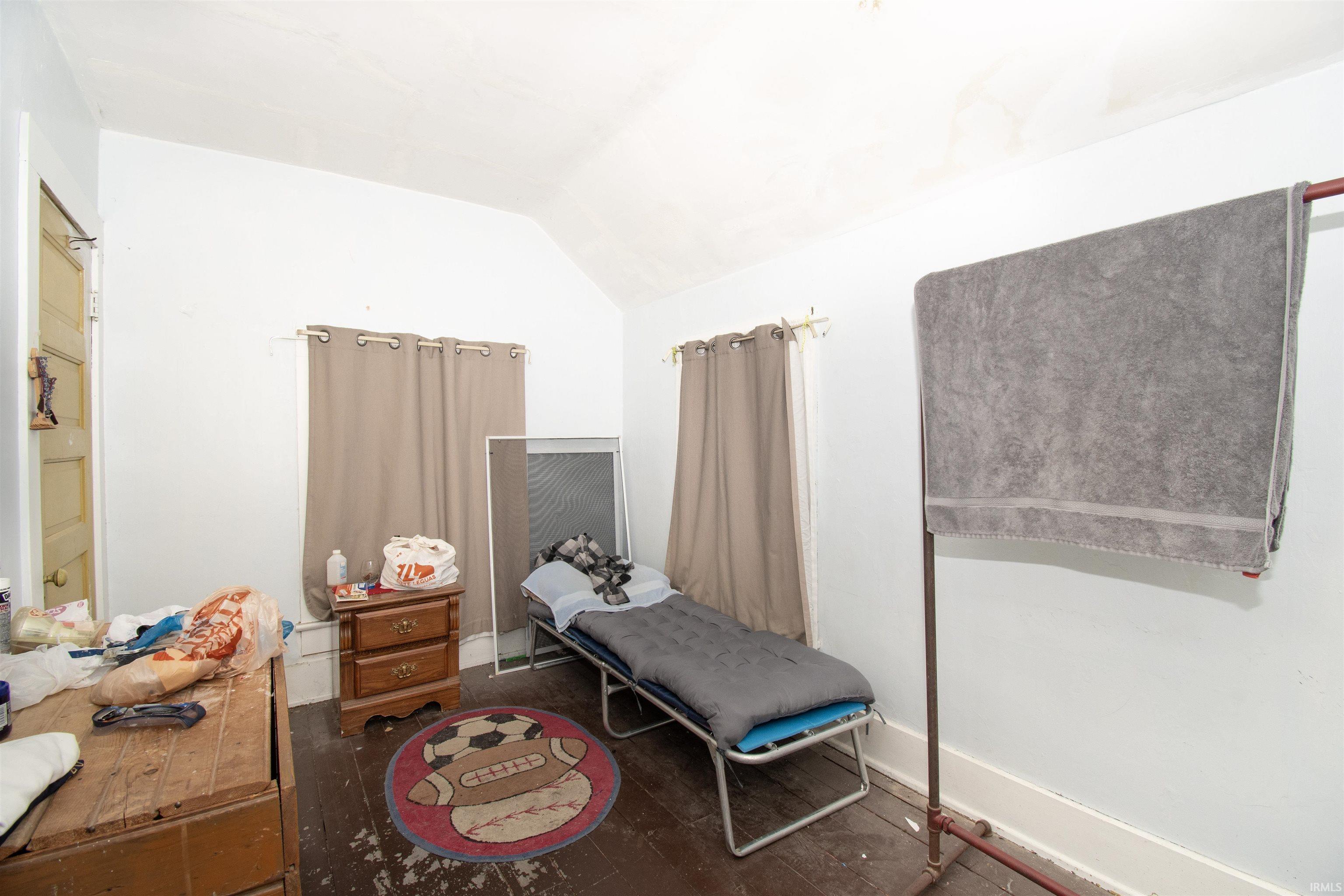 Bedroom with lofted ceiling and dark wood finished floors