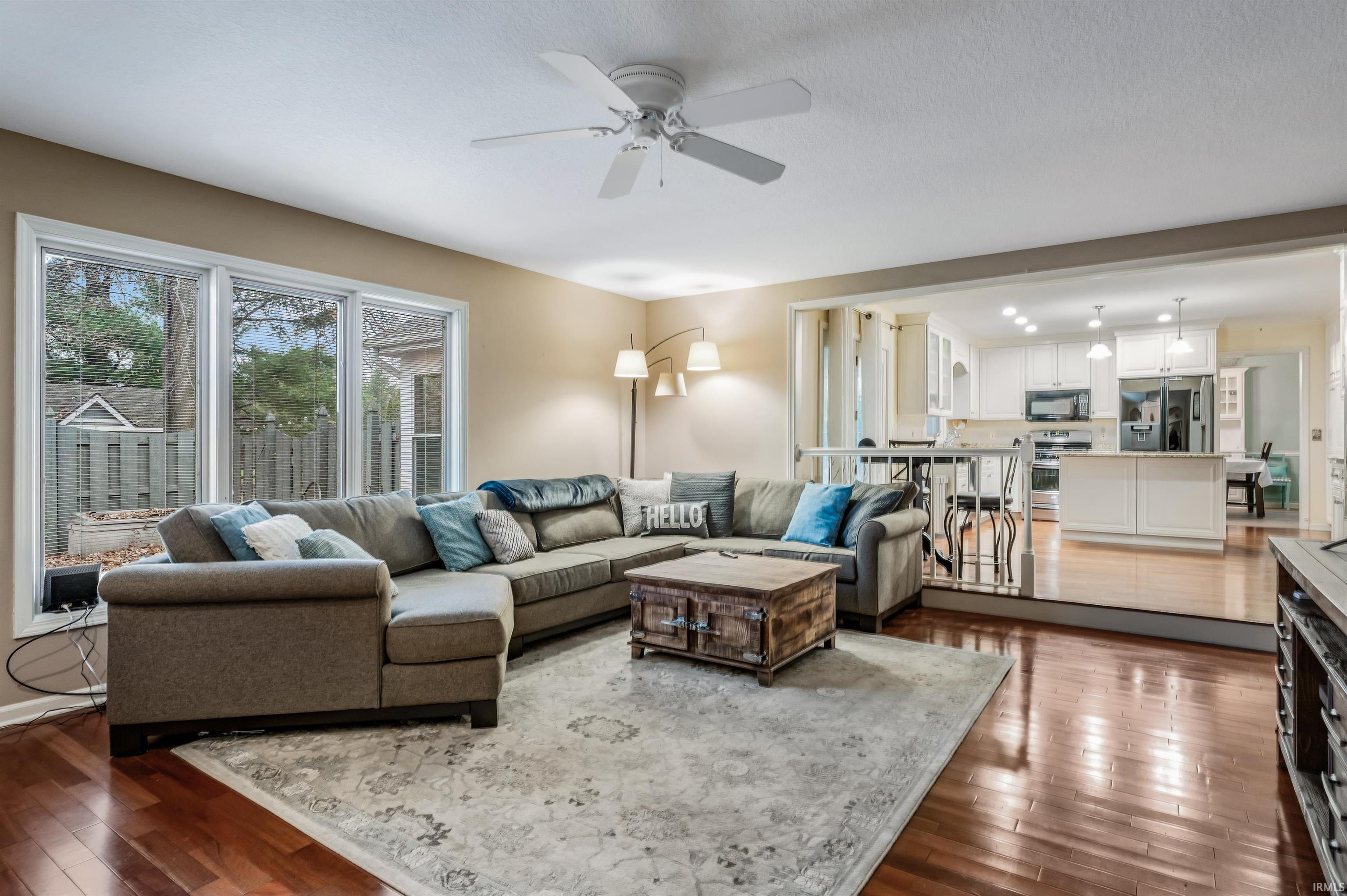 Living area with dark wood-style floors and a ceiling fan