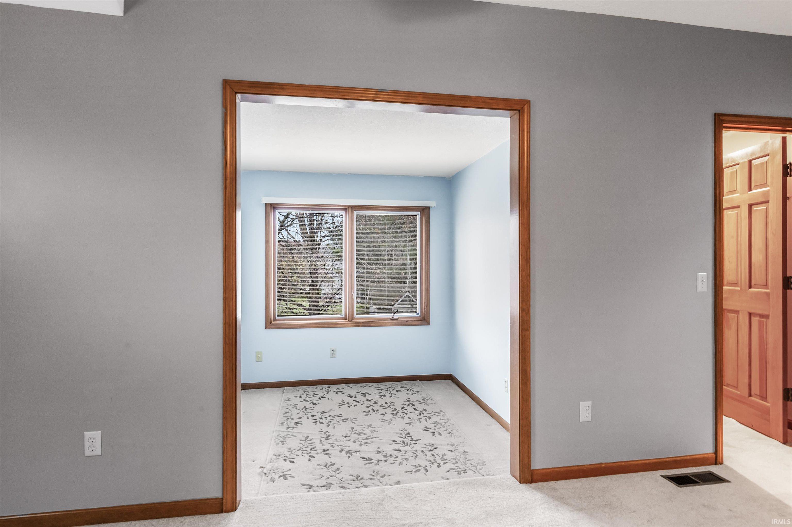 Empty room featuring baseboards and light colored carpet